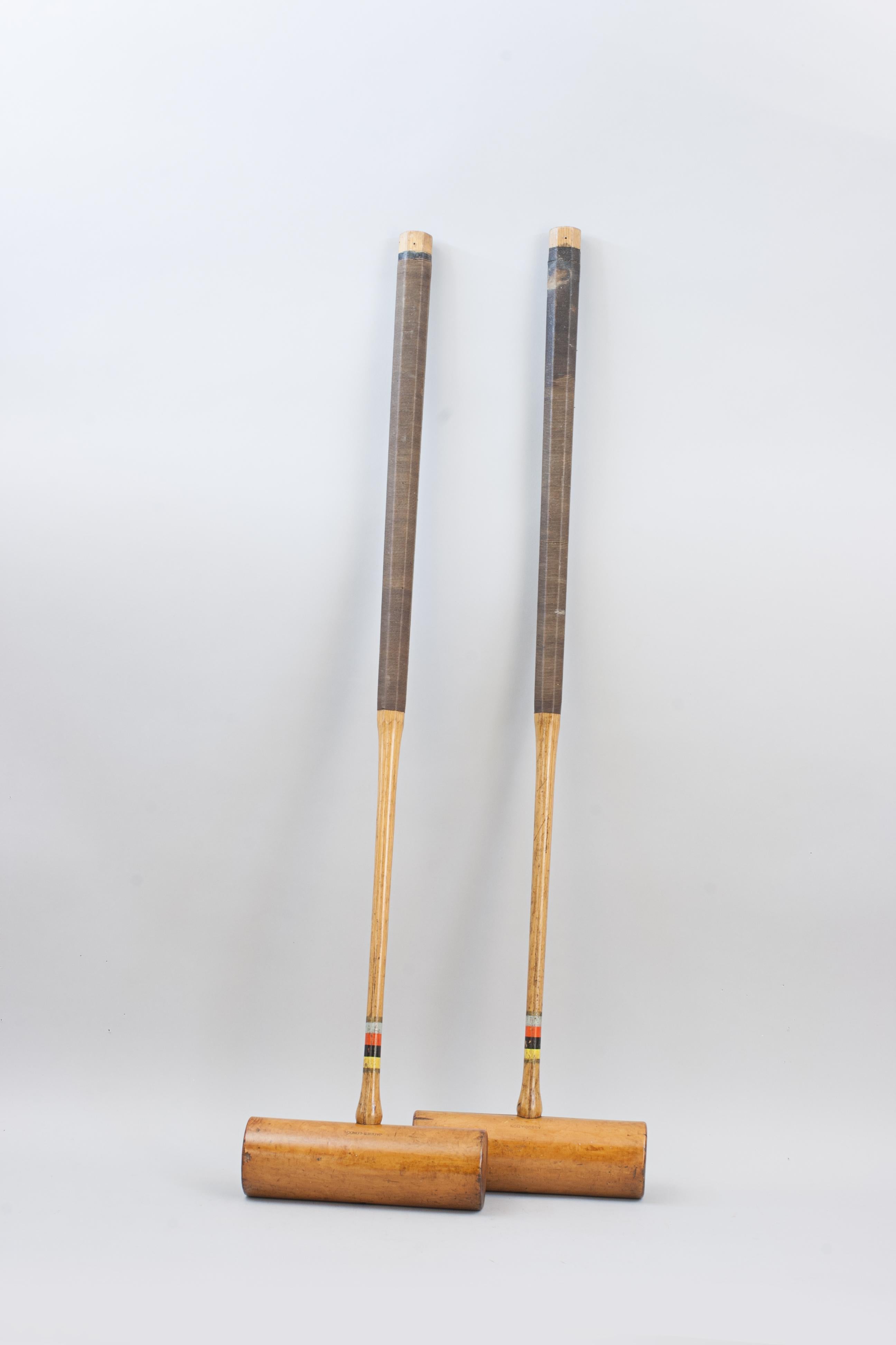 Pair of John Jaques Association Croquet Mallets.
A pair of usable Jaques Boxwood croquet mallets, with ebony alignment lines, octagonal ash handles (which helps a player 'feel' the alignment of the mallet in play) with cord grips. Each head marked