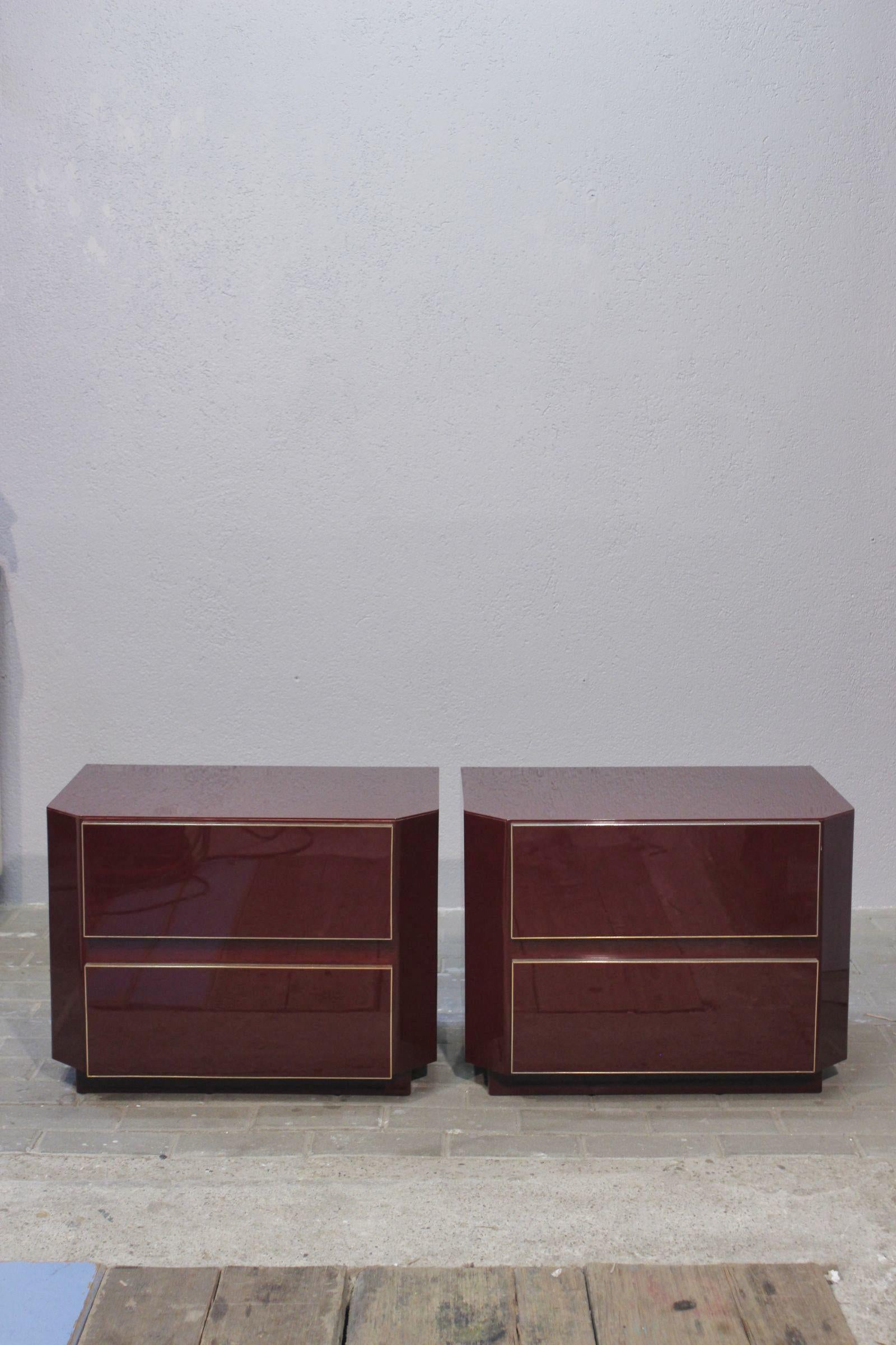 Pair of post-modern bedside tables by Jean Claude Mahey circa 1970, burgundy-red lacquer and gilded brass. Minimalist design and high quality workmanship, typical of French production of the 70s and 80s.

All in good condition, with a few traces of