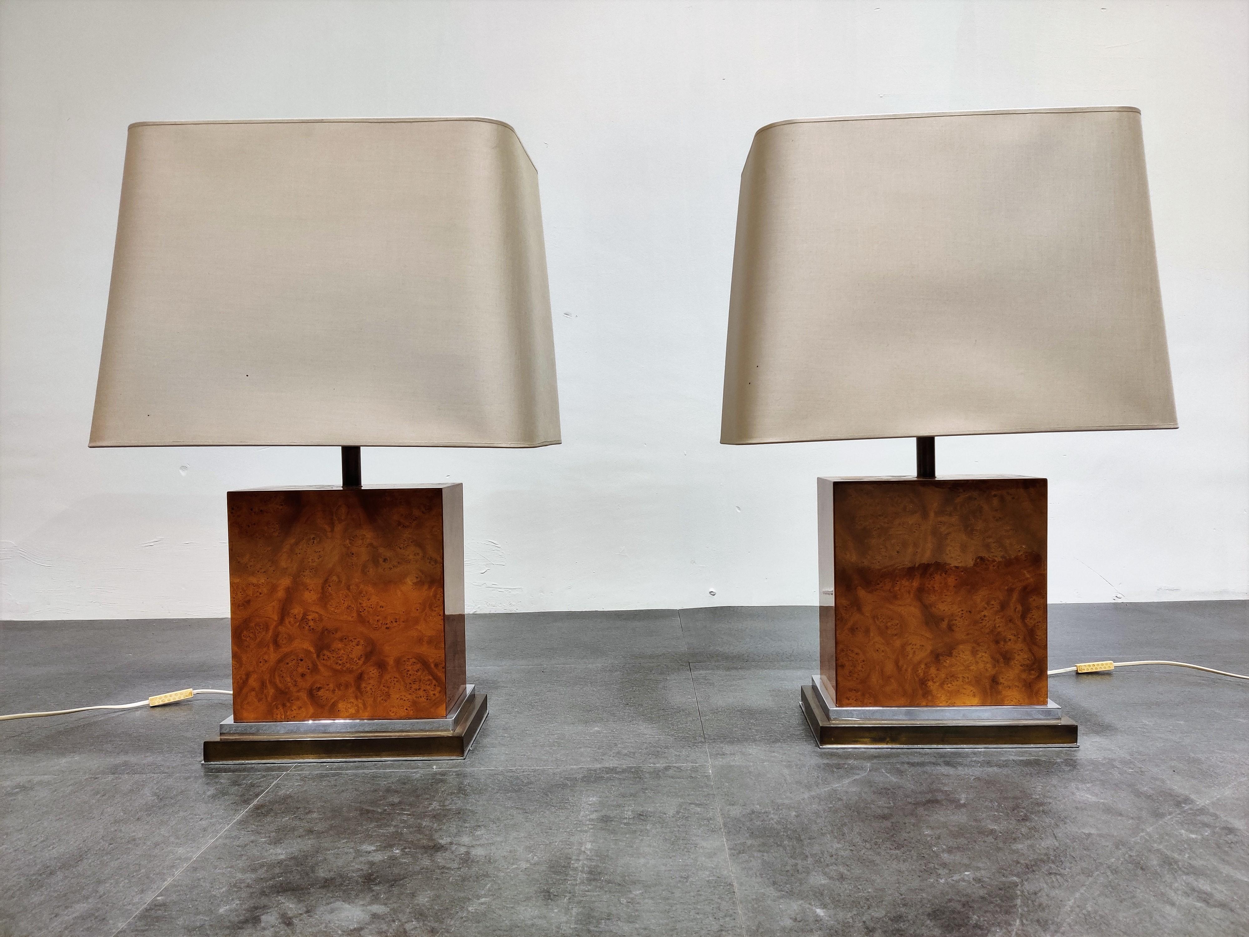 Pair of stunning burl wooden table lamps table lamps by Jean Claude Mahey.

Burl wood mounted on a brass and chrome base with new white lamp shades.

Tested and ready to use with a regular E27 light bulb.

1970s, France

Dimensions:
With