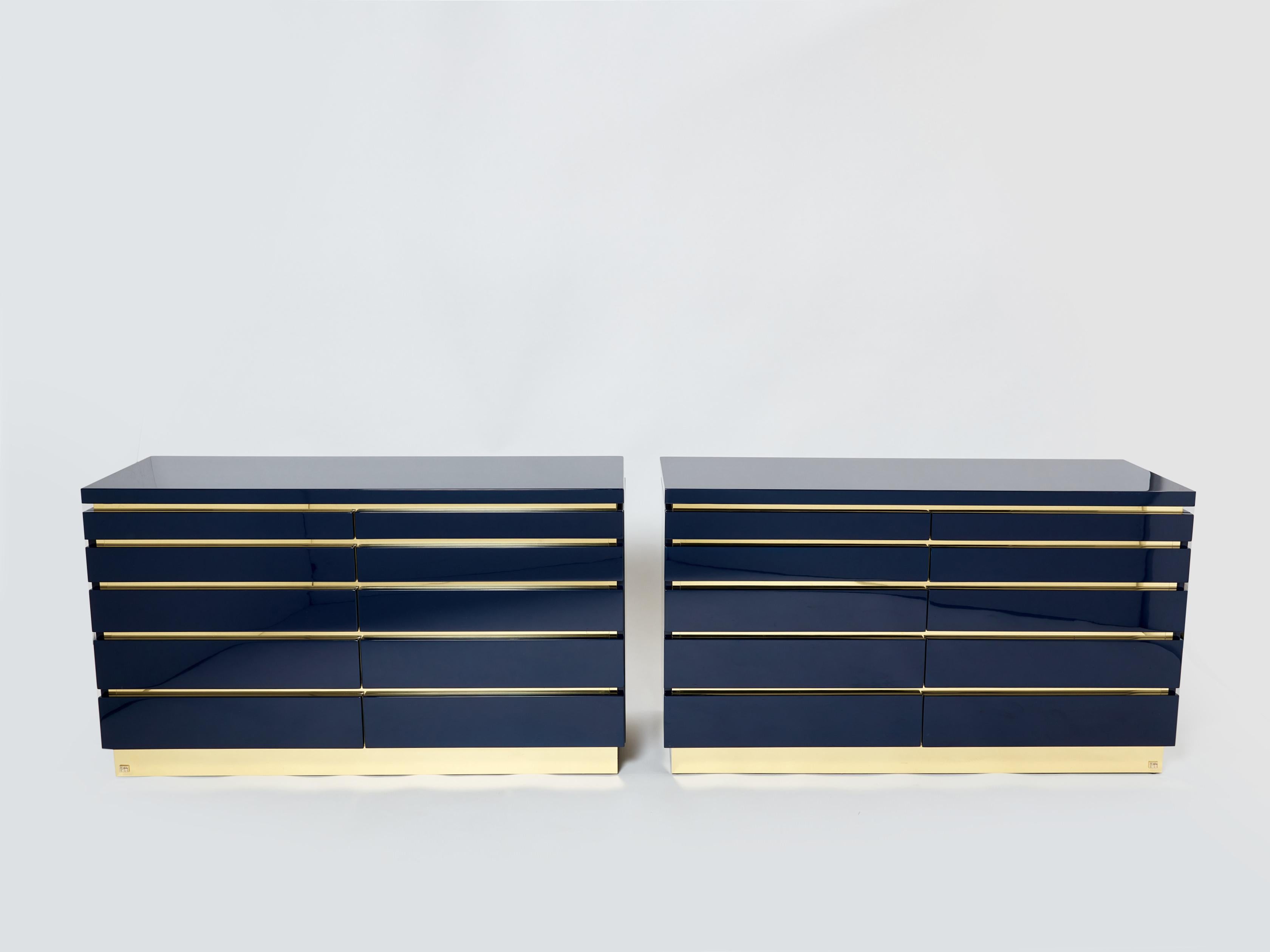 With a shining dark ocean blue lacquer finish, and brass standing and details between the ten drawers, this beautiful pair of chest of drawers carries a stellar French mid-century aesthetic into the contemporary home. Its boxy yet sophisticated
