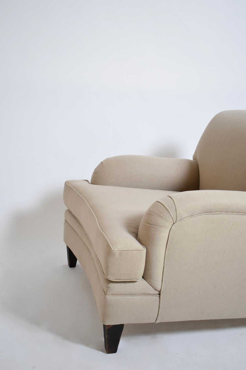 Pair of Jean Michel Frank style armchairs in beige fabric and dark wood profiled square feet, the front slightly incurved. France, 1960s.
