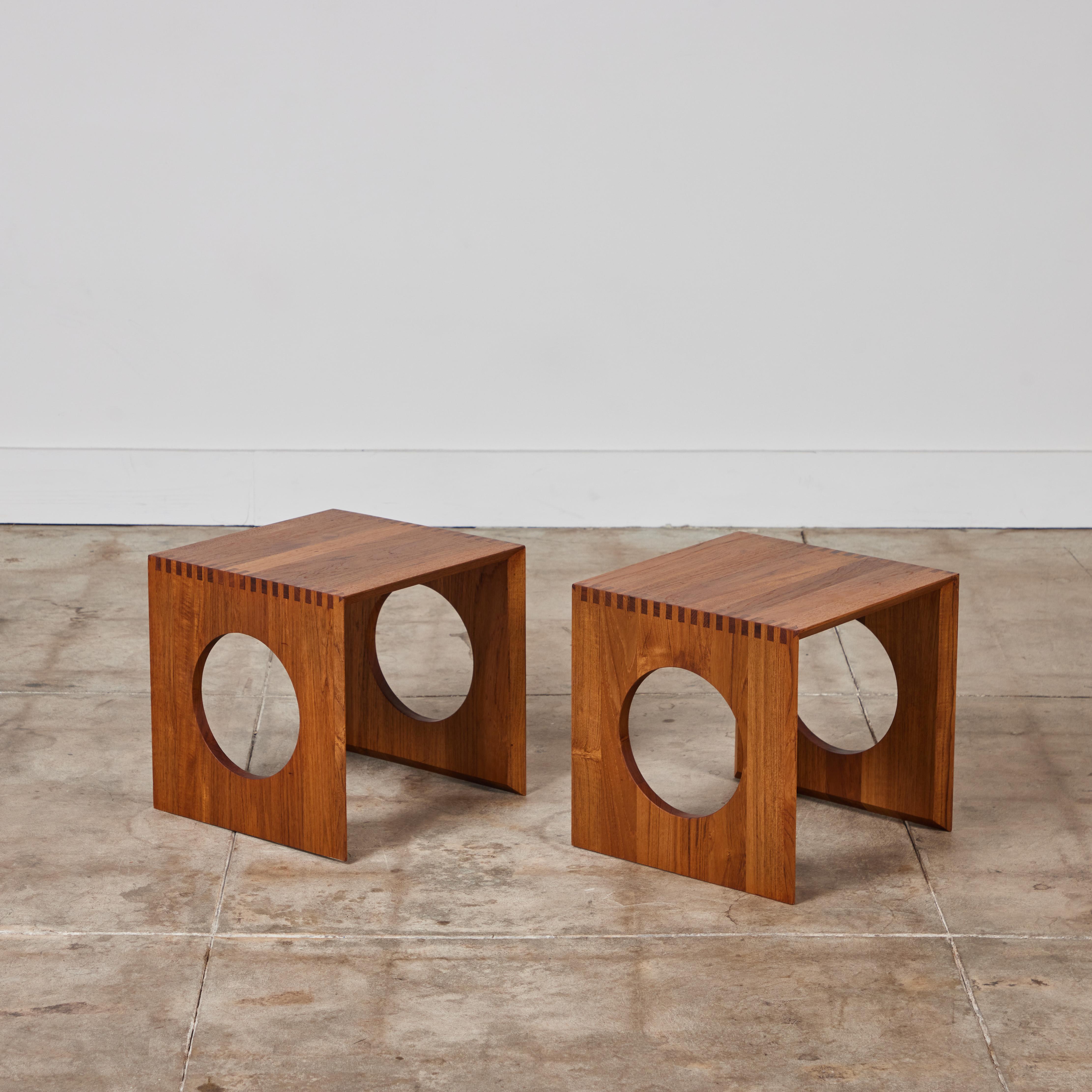 Pair of side tables by Jens H. Quistgaard for Nissen, c.1960s Denmark, features a hand-oiled teak frame with finger joinery and circular cutouts on each side. The tables can interlock forming a single cube table.

Dimensions
14.25