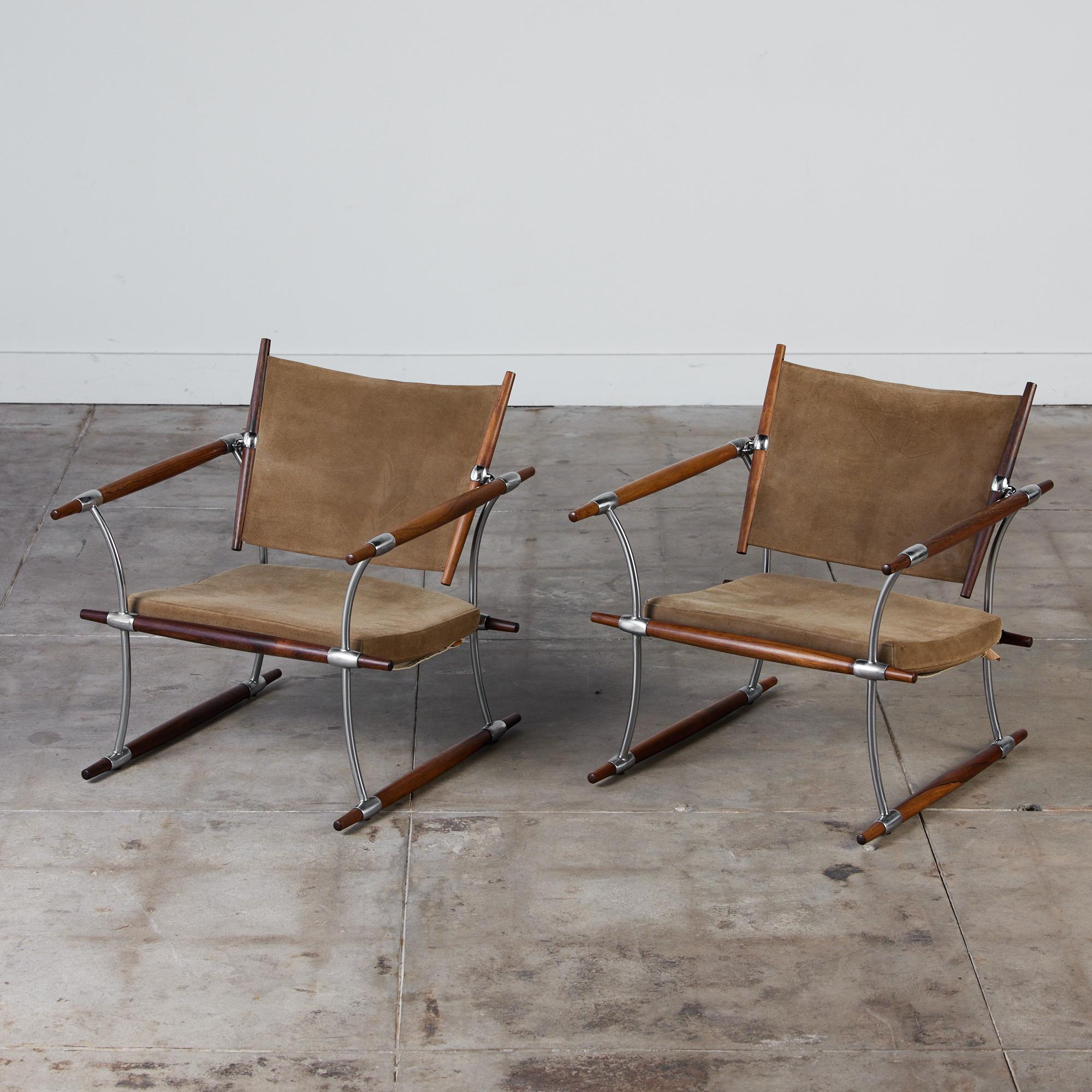 A pair of 'Stokke' lounge chairs by Jens H. Quistgaard for Nissen, c.1960s Denmark. The sling backrest and seat cushion feature the original taupe suede. The frames of these chairs are composed of rich Rosewood dowels and chrome plated steel, a