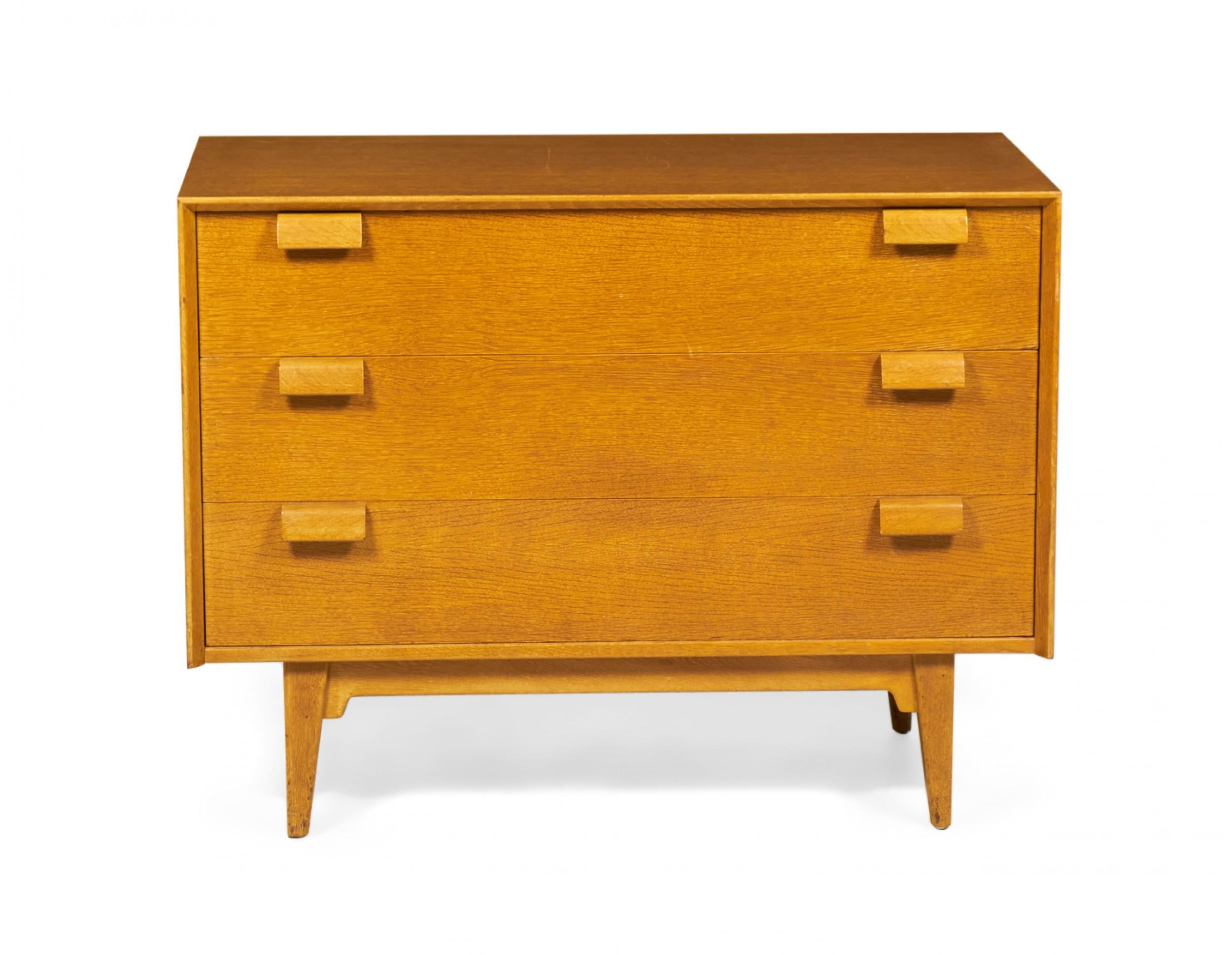 PAIR of Danish Mid-Century chests / dressers with three drawers with angled wooden drawer pulls in a blond oak case resting on tapered wooden legs. (JENS RISOM)(PRICED AS PAIR)
