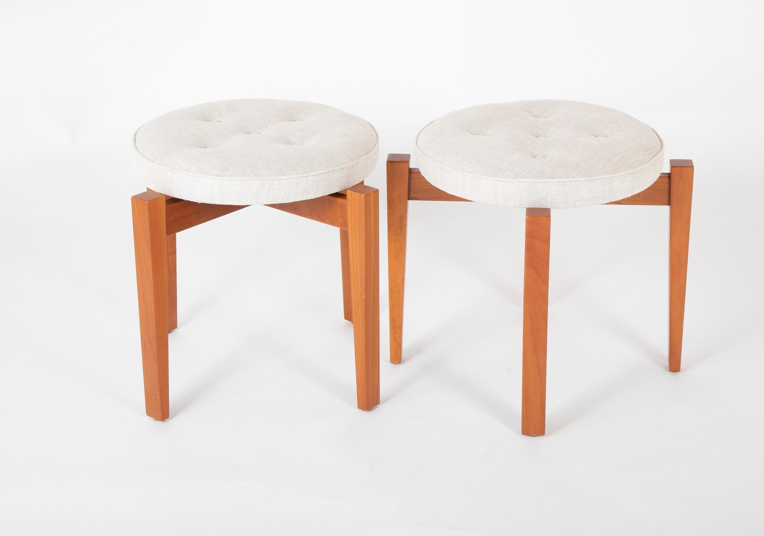 A pair of walnut stools designed by Jens Risom for Ralph Pucci. Originally designed for Philip Johnson's Glass House in New Canaan, CT. Signed to underside : [ Jens Risom ] with applied metal manufacturer's label [ The Glass House Stool Design :