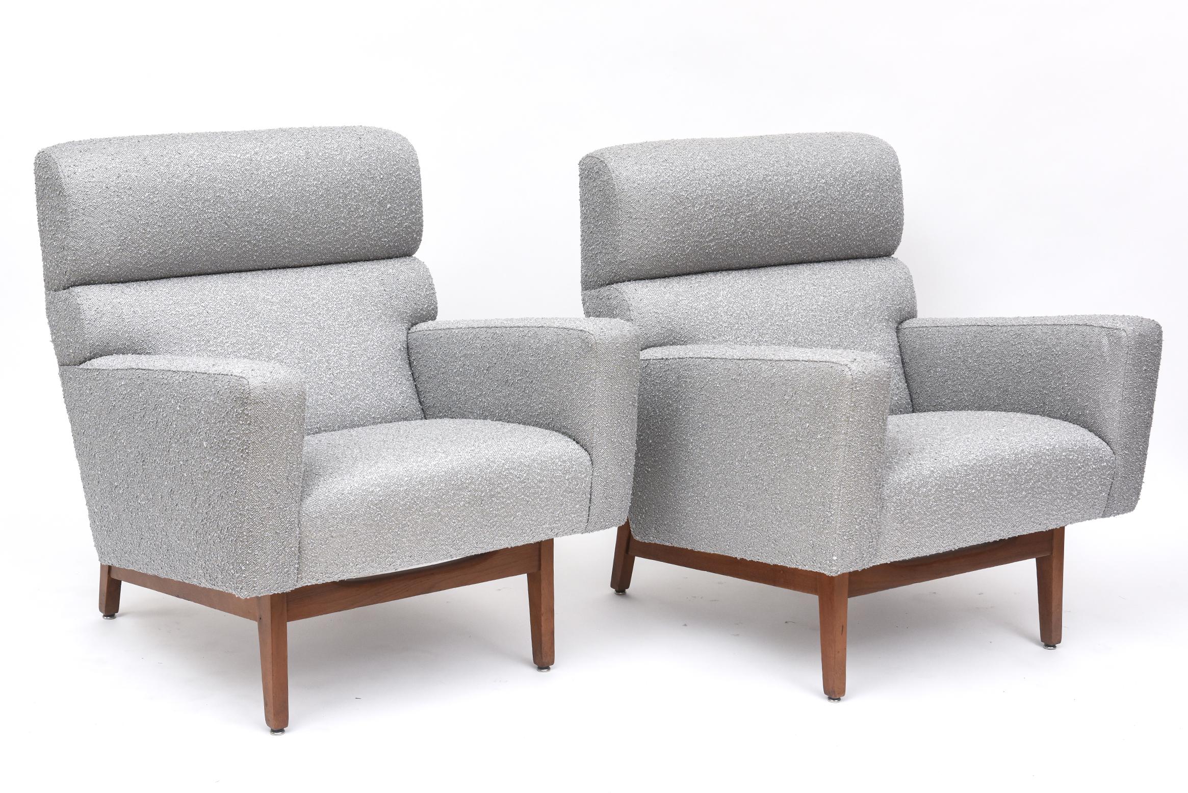 Stylish and comfortable, these meticulously restored pair of American mid-century modern lounge chairs by Jens Risom have new silver boucle upholstery on walnut bases. Originally born and trained in Copenhagen, Risom was responsible for bringing
