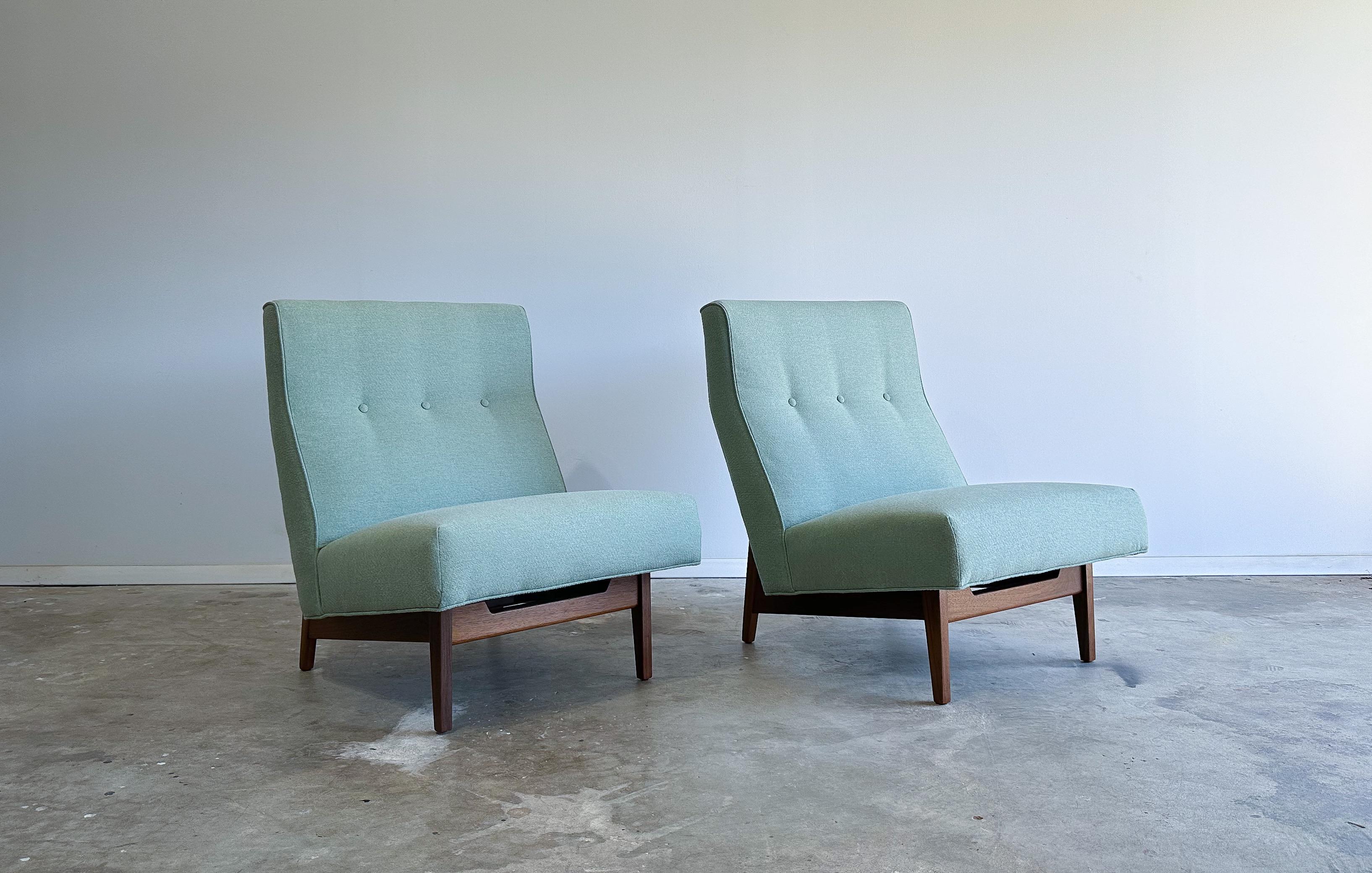Offered is a wonderful pair of slipper chairs designed by Jens Risom. 

Featuring sleek, solid walnut frames that appear to cradle the newly upholstered seats. We would call the fabric color sage, or pistachio. The warm walnut frames really