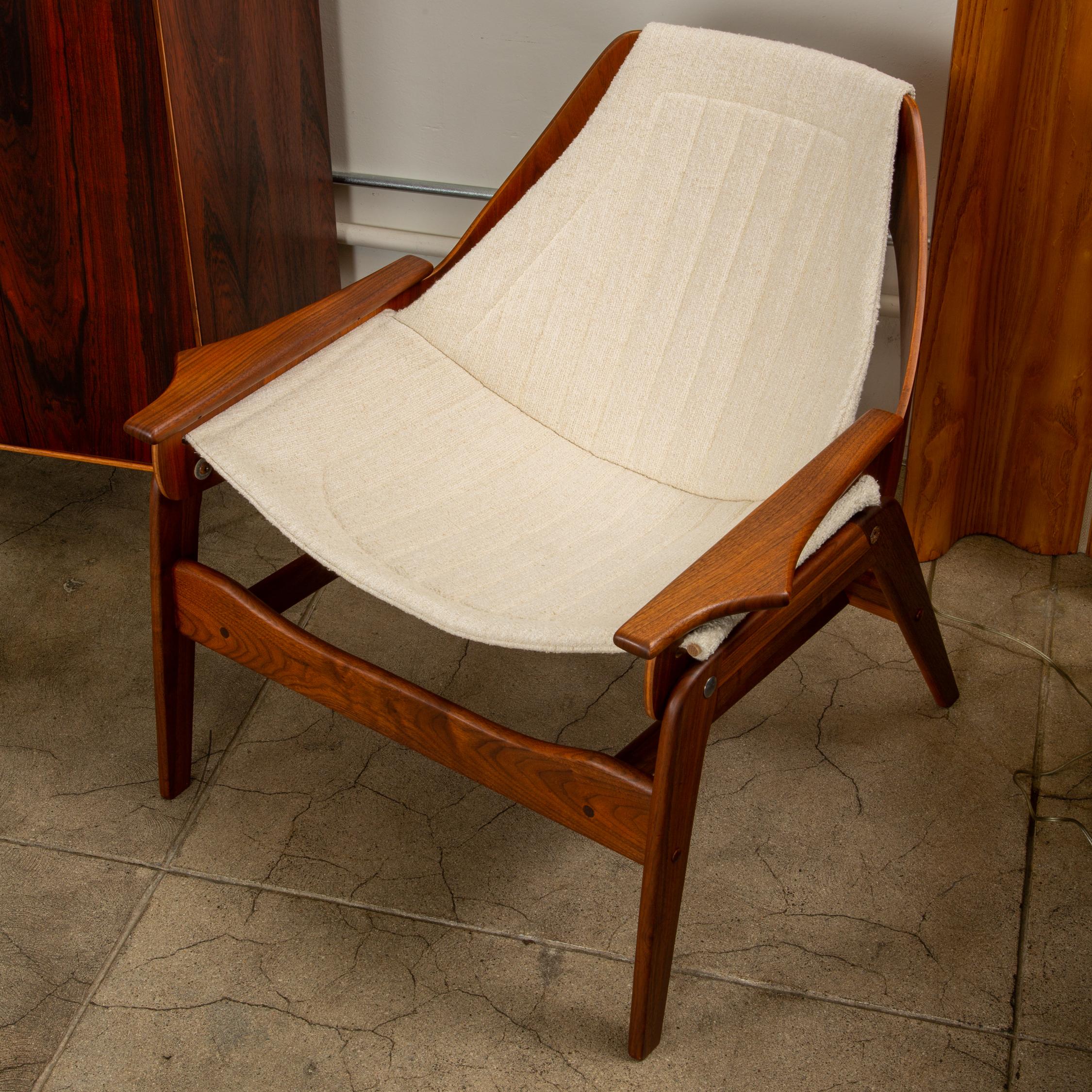 A pair of walnut sling lounge chairs by Jerry Johnson designed in 1968. The refinished walnut frames support a newly upholstered off-white bouclé fabric sling. 

Condition: Excellent vintage condition, both chairs professionally refinished and