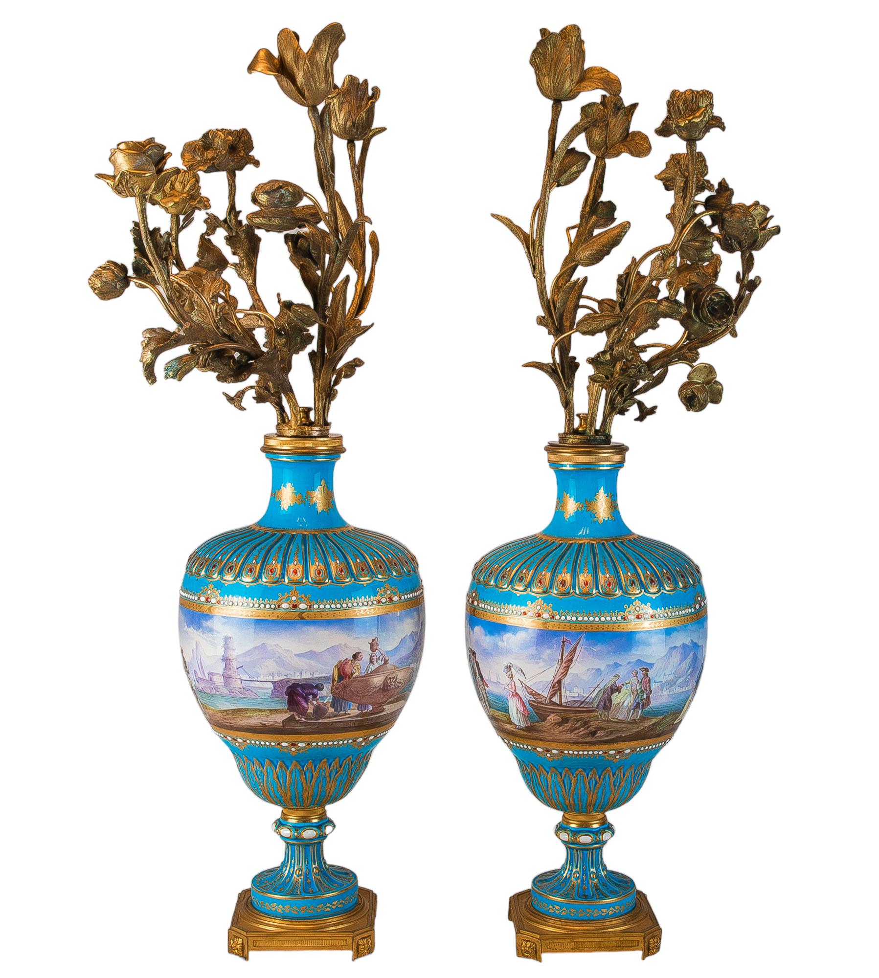 A grand pair of sérves-like turquoise picture vases mounted as five light bouquet candelabras. Hand painted with scenes of a quaint European port town in the 18th century. Each vase showcases a figure group on each face, with one depicting the daily