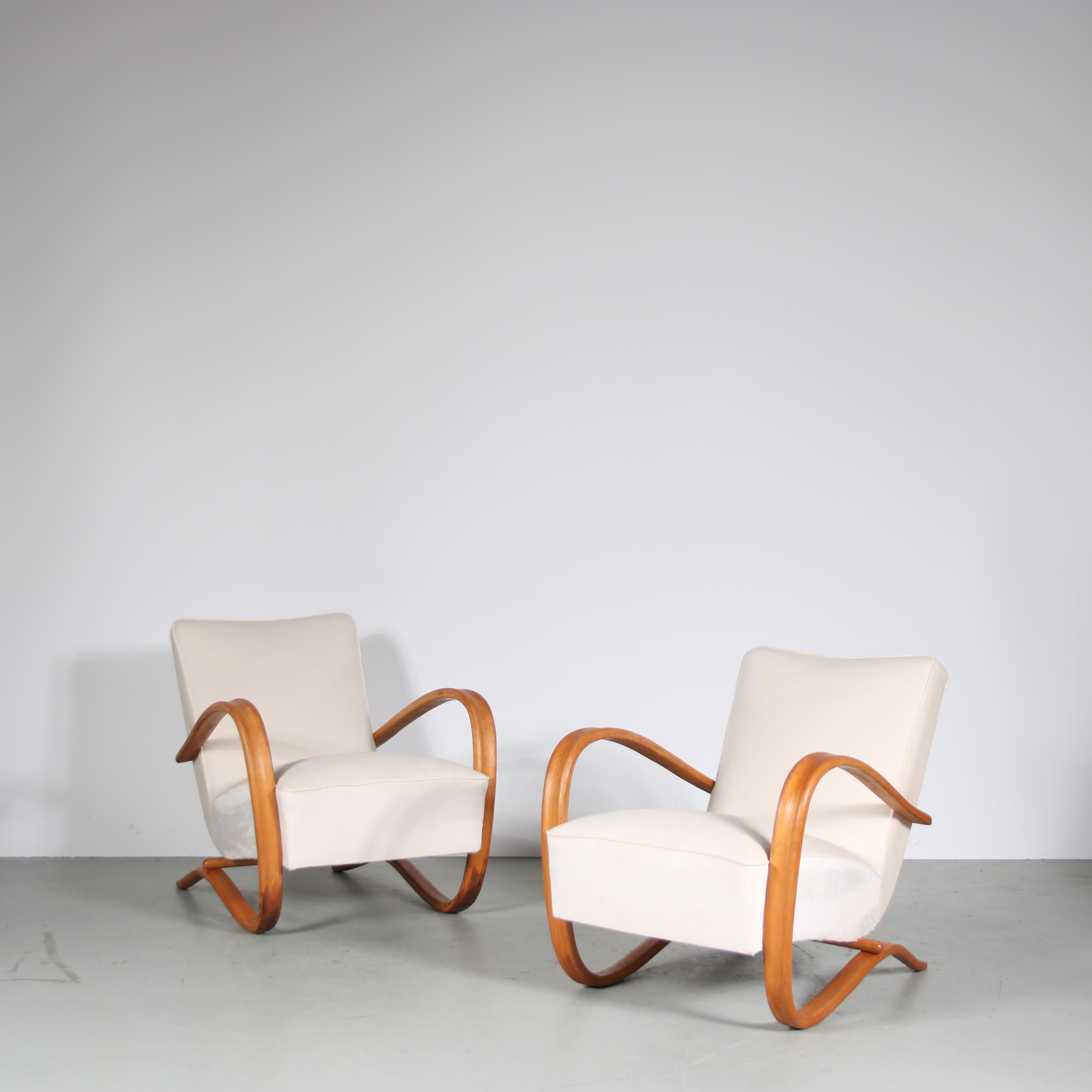 An iconic pair of lounge chairs in eye-catching Czech design by Jindrich Halabala, manufactured by Up Zavody in the Czech Republic around 1930.

These chairs have a beautiful art deco style. The light wooden curved armrests transition smoothly into