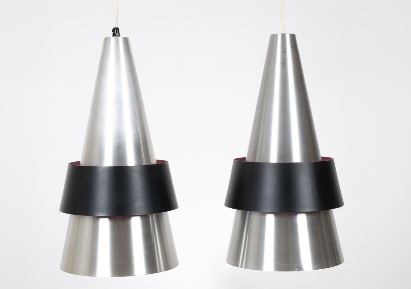A striking pair of Scandinavian midcentury conical pendant lights in brushed aluminum and black powder coated shades, with sprayed pink interiors. Designed by Jo Hammerborg for Fog & Morup, circa 1963, these model 