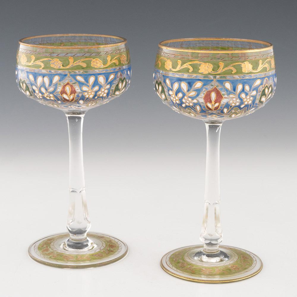 Heading : Pair of Jodhpur enamelled wine glasses
Date : c1900
Origin : Josephinehutte, Schreiberhau, Silesia, Germany
Bowl Features : Green enamel band with foliate detailing above a blue enamel band with red and green and yellow detailing with