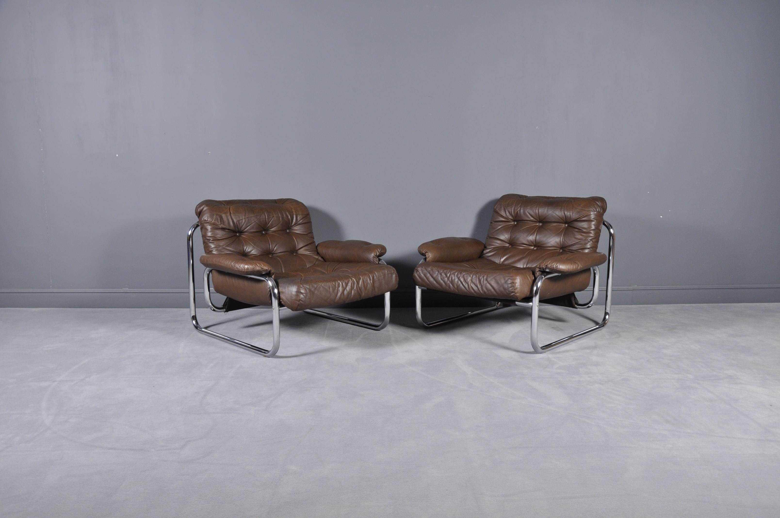 Pair of Swedish 1970s tubular metal framed lounge chairs with original brown tufted cushion and arm rests. Produced by Ikea, model Troligen, designed by Johan Bertil Häggström.
Three-seat sofa available in the same model.