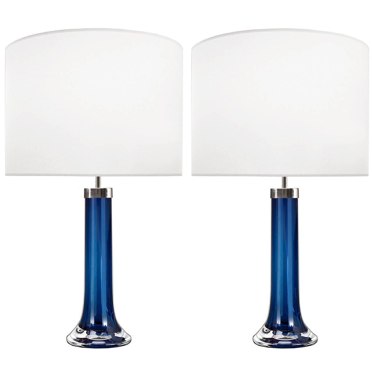 A pair of blue glass lamps with thick clear casing and nickel hardware by Johansfors.

Swedish, Circa 1960's

Lamp Shades Are Not Included.

If you are interested in Lamp Shades, please email The Craig Van Den Brulle Design Team Via Message Center,
