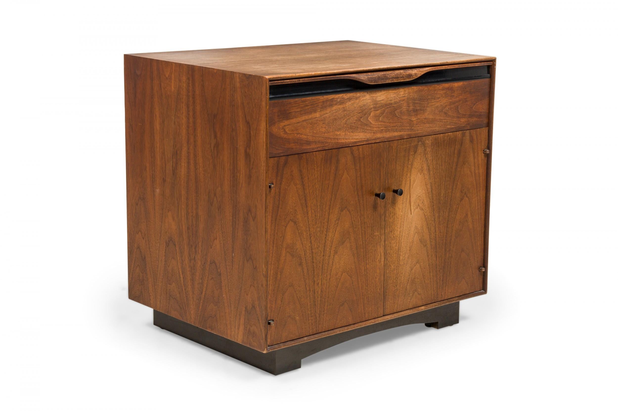 Pair American mid-century walnut bedside tables / commodes with walnut cabinets and a single drawer above a two door cabinet. (JOHN KAPEL FOR GLENN OF CALIFORNIA)(PRICED AS PAIR)