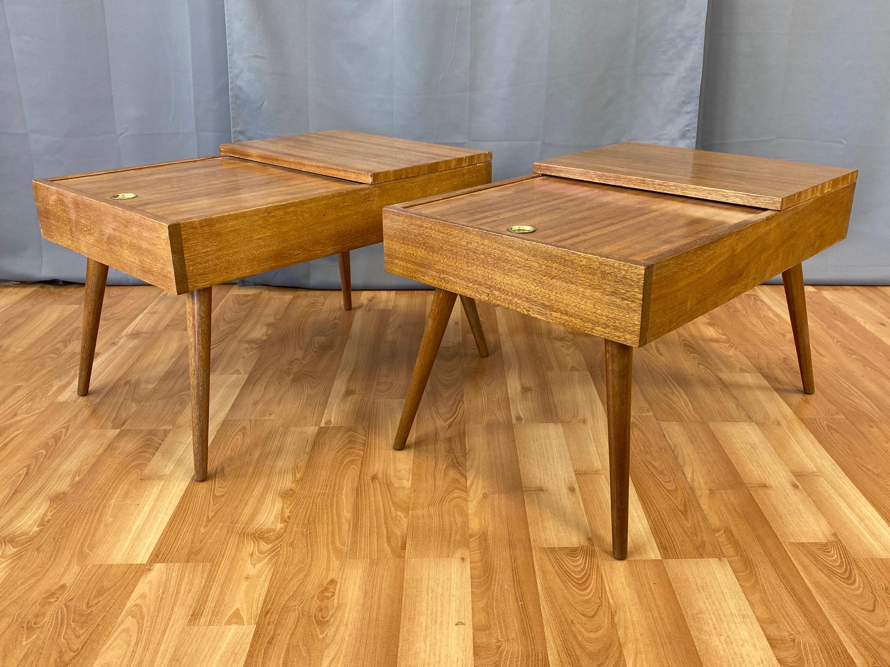 A handsome pair of professionally refinished 1950s model 84 blonde ribbon mahogany sliding top end tables with concealed storage compartment by John Keal for Brown-Saltman.

Top with the upper level fixed and of nice size for a small table lamp, and