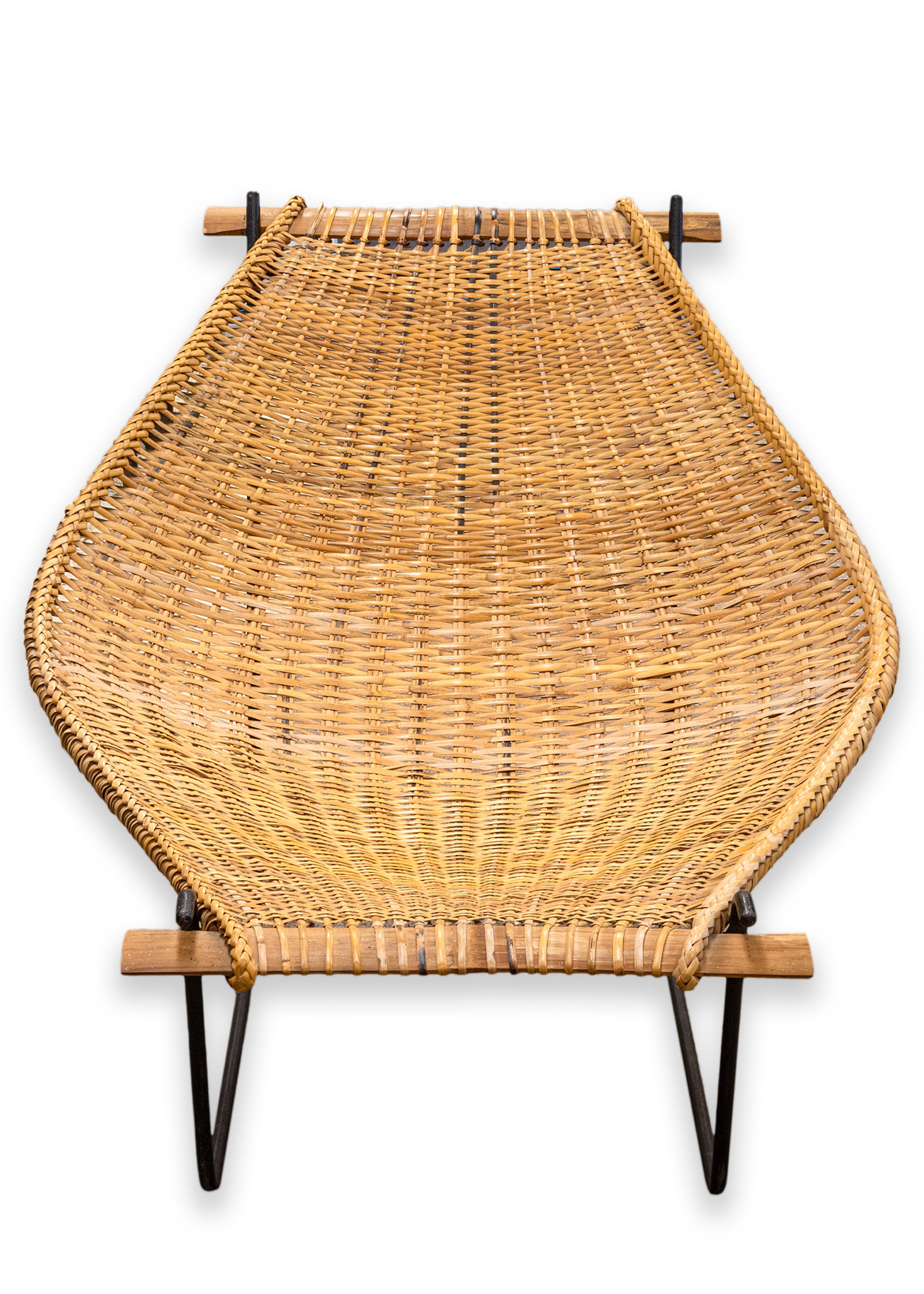 A pair of John Risley Duyan chairs for Craft Associates. A lovely set of chairs featuring a playful mid century modern design by John Risley. These lounge chairs feature a wrought iron frame, and a one piece rattan seat. The seat tucks into the