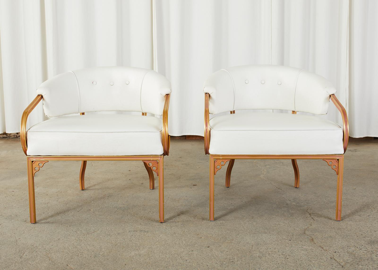 Mid-Century Modern pair of chic armchairs or lounge chairs designed by John Van Koert for Troy Sunshade Co. Made in the fabulous Florida Regency style featuring a cast aluminum frame having a barrel back form and gracefully curved scroll arms. The