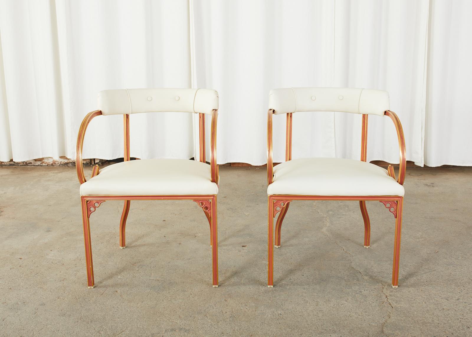 Mid-Century Modern pair of chic armchairs of lounge chairs designed by John Van Koert for Troy Sunshade Co. Made in the fabulous Florida Regency taste featuring a cast aluminum frame with a barrel back form of dramatic scroll arms. The aluminum is