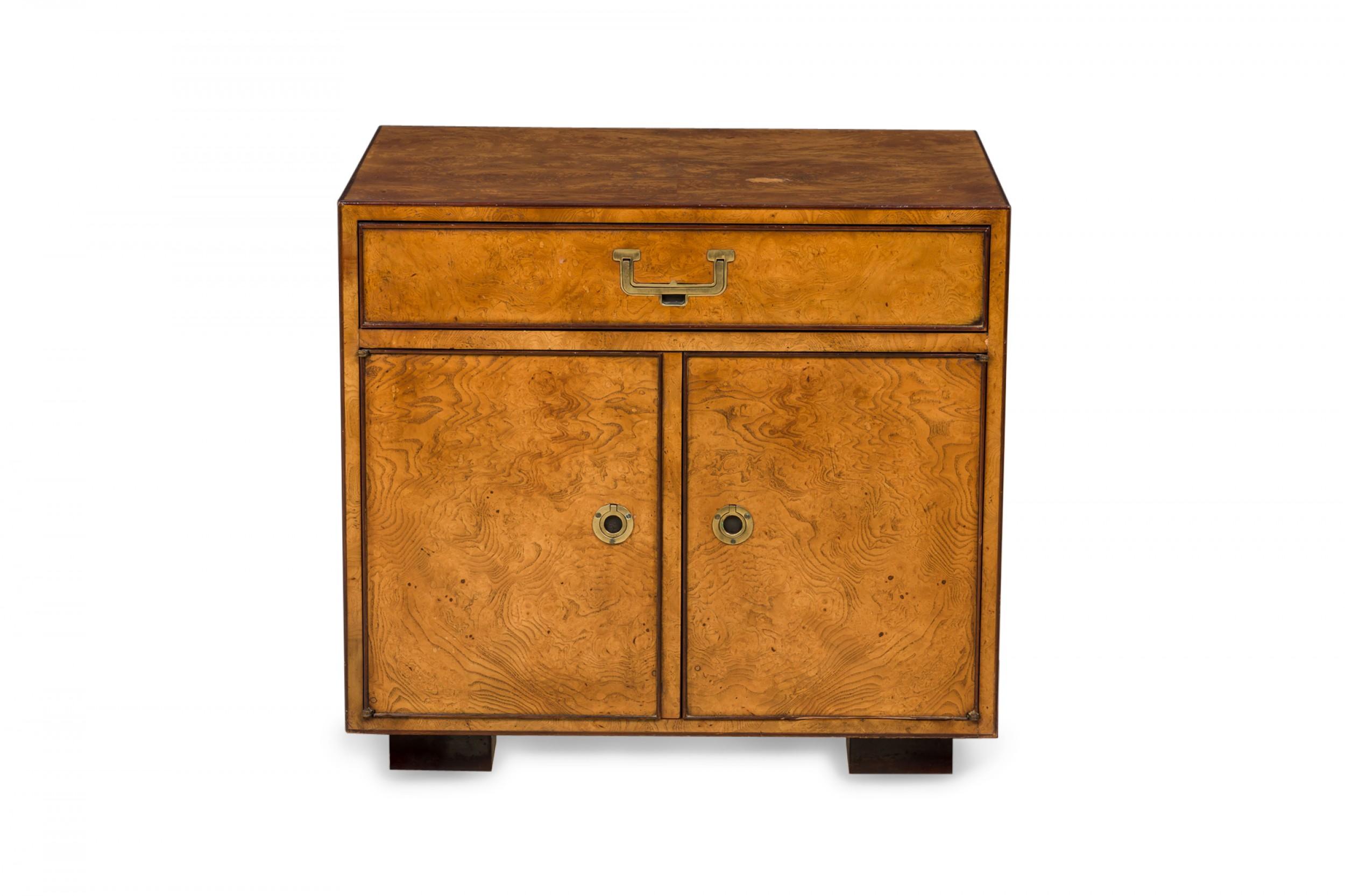 Pair of American mid-century nightstands / commodes with a burl wood veneer, single drawer with brass pulls, and two cabinet doors with brass pulls below. (John Widdicomb)(Priced as Pair).
   