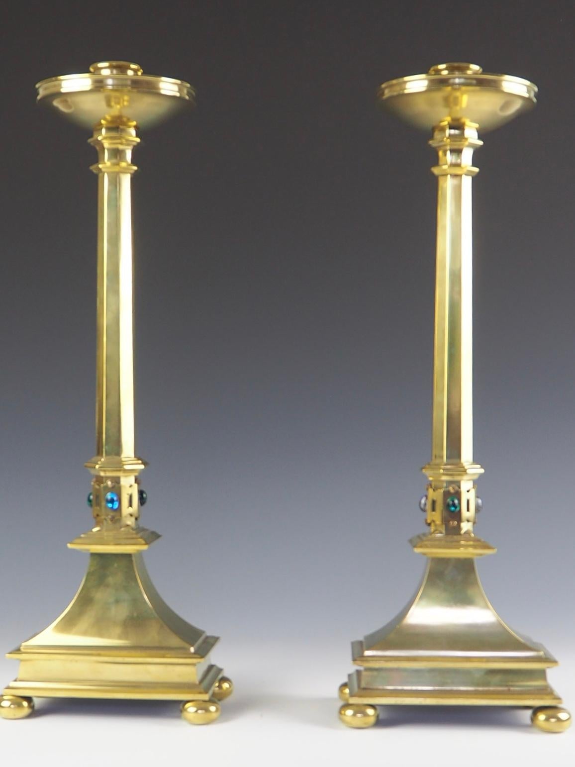 Pair of Jones and Willis Church brass tall candlesticks with Cabouchon Hard-Stones
Decorative late 20th century Church brass candlesticks. The candlesticks consist of a rimmed edge with a drip pan.
Leads down to a column, at the base of the column