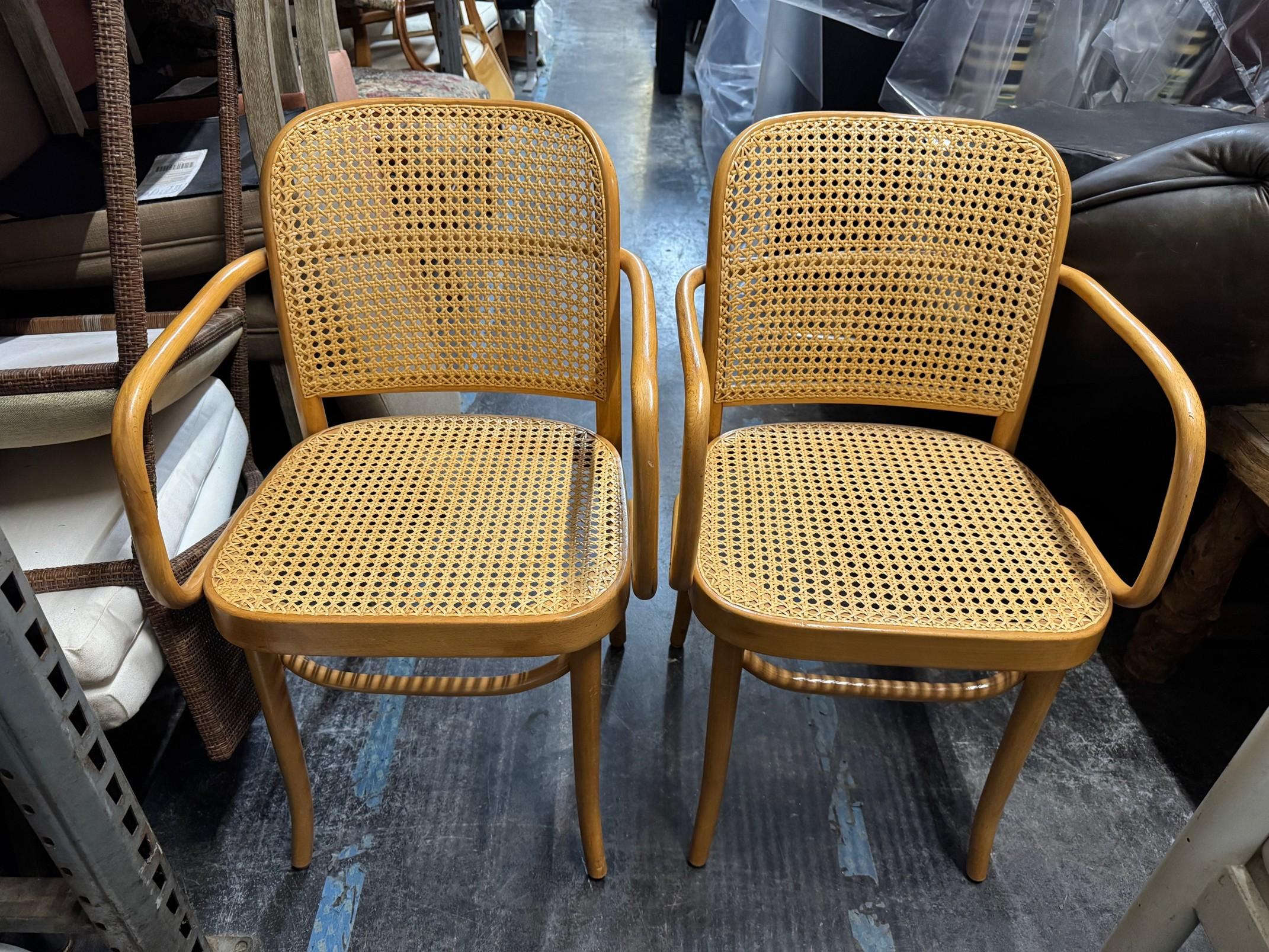 Rare pair of No. 811 Thonet armchairs or Prague chairs designed by Josef Hoffman. The chairs feature an iconic bentwood frame design with square shaped arms and a caned seat and back. Excellent joinery and craftsmanship given age and use with a