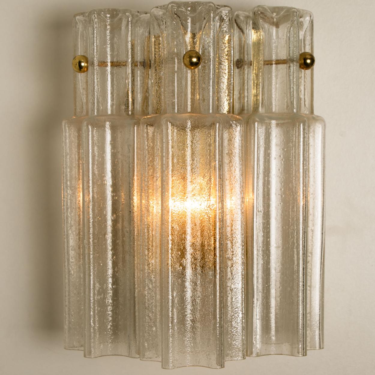 A wonderful pair of Murano glass wall lights designed by J.T. Kalmar for Kalmar Franken, Vienna, Austria. Manufactured in circa 1960s. These wall lights are handmade and a high quality pieces. Murano tubes in clear glass hanging on a brass plate.
