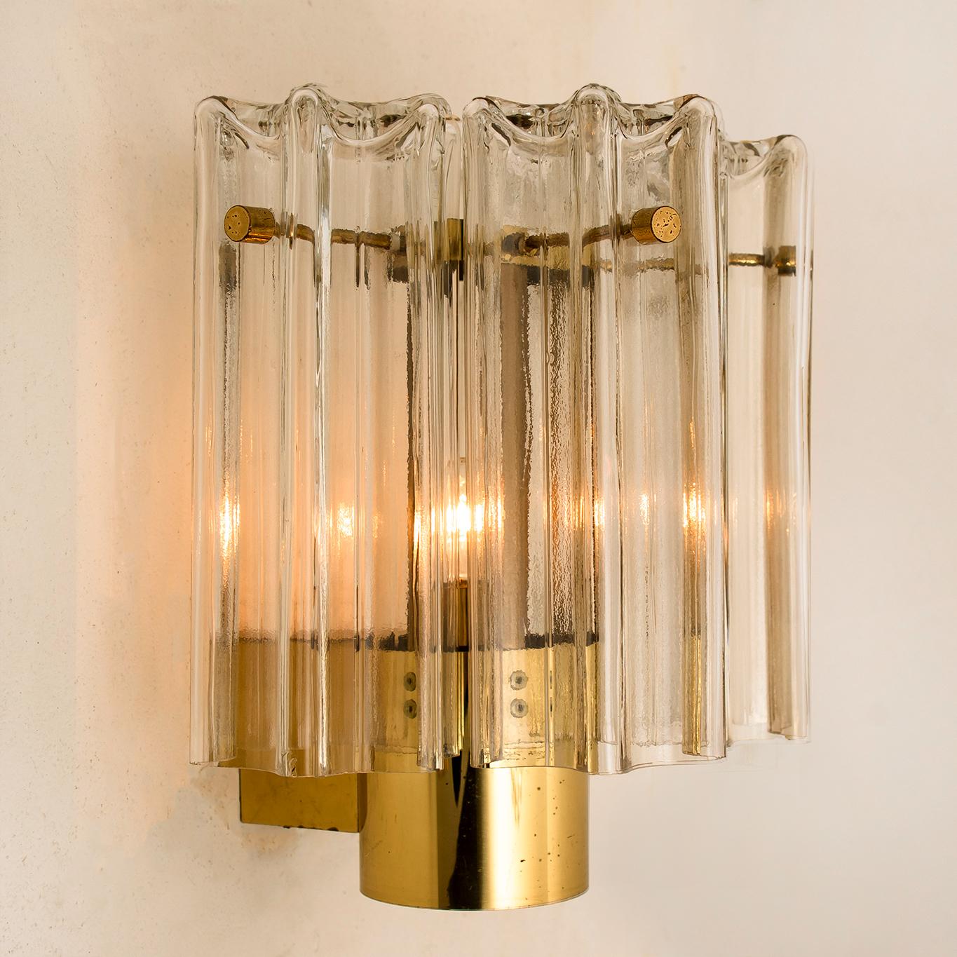 A wonderful pair of Murano glass wall lights designed by J.T. Kalmar for Kalmar Franken, Vienna, Austria. Manufactured in circa 1960s. These wall lights are handmade and a high quality pieces. Murano tubes in clear glass hanging on a brass plate.