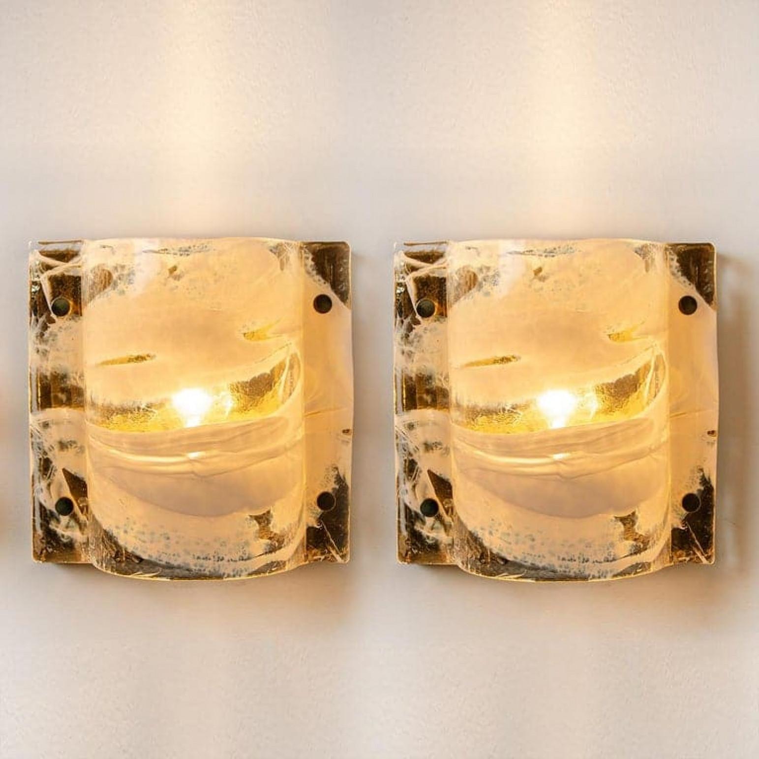 Pair of elegant J.T. Kalmar sconces featuring thick white and clear swirl glass on a gilded brass base. Minimalistic design executed with a taste for excellence in craftsmanship. Illuminates beautifully.

Please notice the price is for one pair.
In