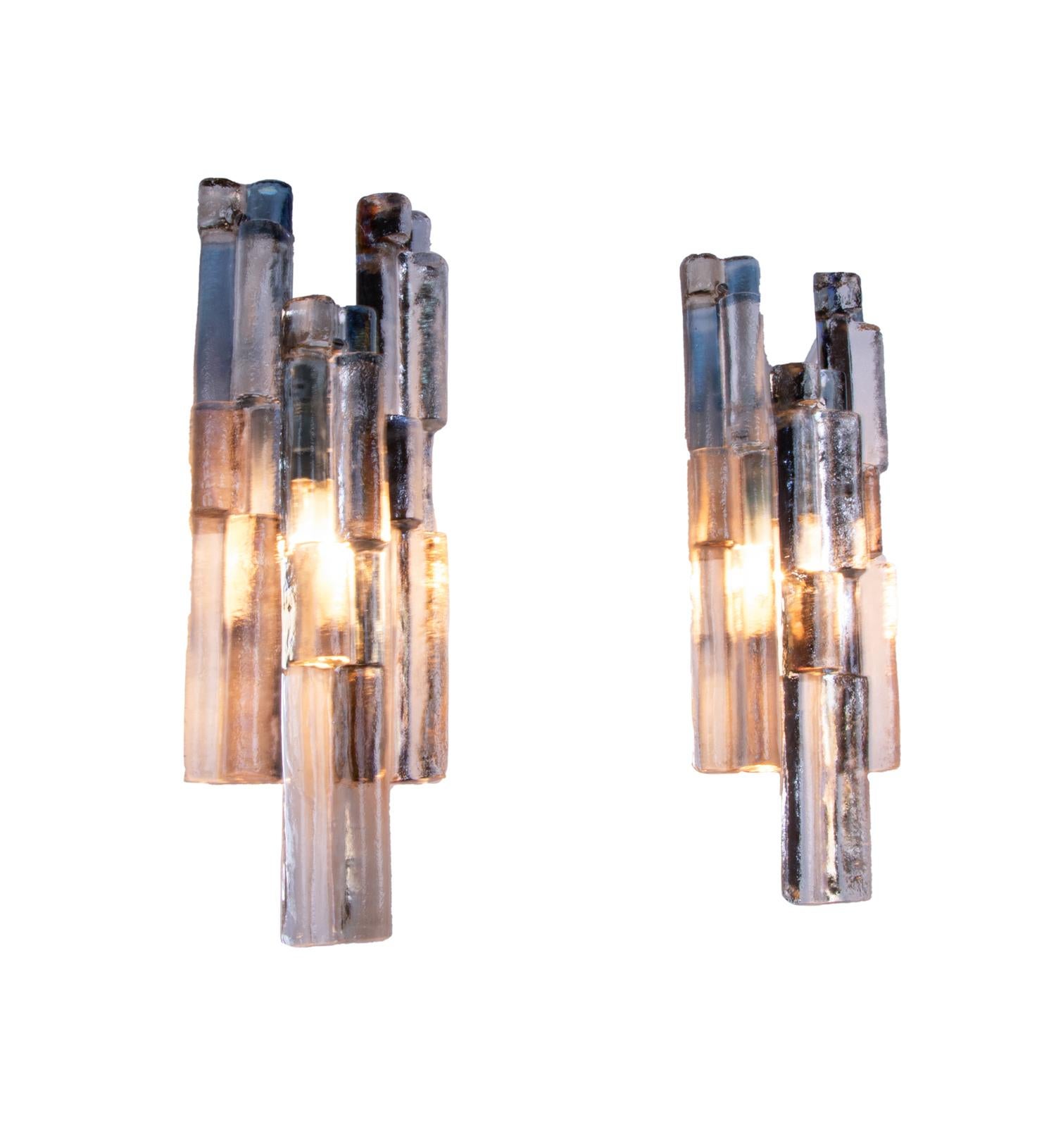 Elegant pair of multicolored Murano glass wall lights designed by J.T. Kalmar made of textured clear glass elements with blue, smoke, amber and clear tinting suspended on a white lacquered nickel backplate. 

Beautiful play of light and colors when
