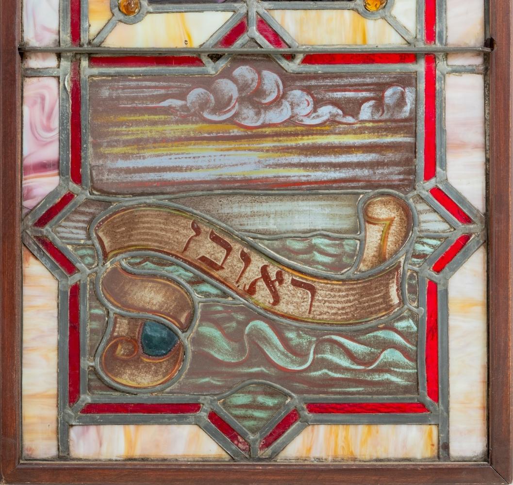 Coppia di vetrate a piombo Judaica, inizio XX secolo, ciascuna decorata con pannelli di vetro colorato, bandiere, pecore e stendardi con l'iscrizione in ebraico 
