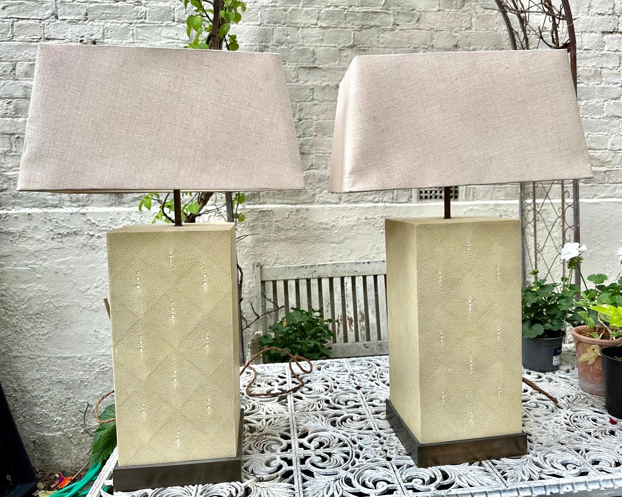 Attractive and imposing pair of Rene lamps by Julian Chichester in ivory colour faux shagreen with bronzed metal bases. 
In near perfect condition. 

H 60cms 
W 22cms 