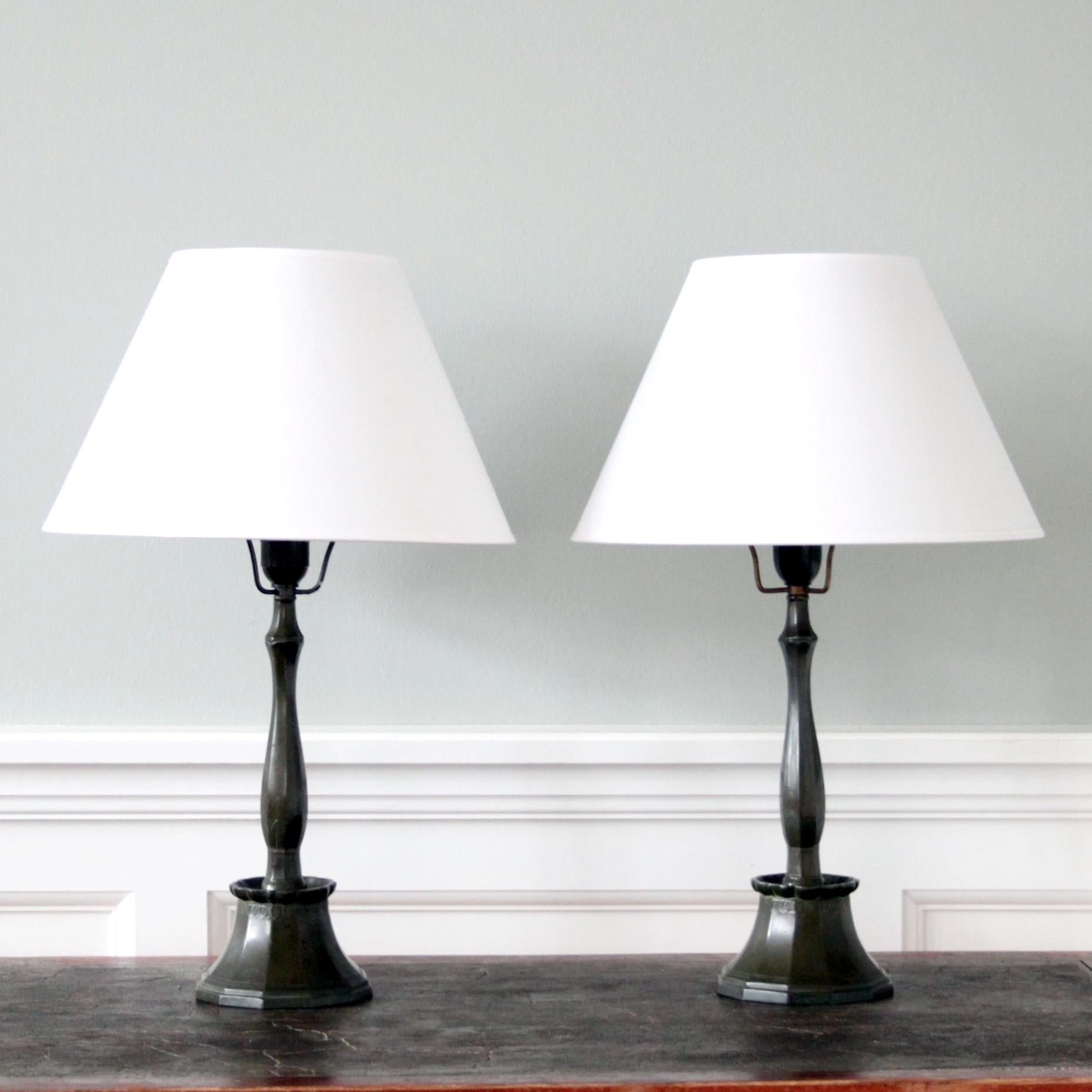 JUST ANDERSEN 

An early and beautiful pair of Art Deco table lamps in dark patinated disko metal. 

This decorative pair of lamps were made by Danish designer and pioneer Just Andersen in 1920s. 

Dessin D2, stamped underneath. 

A beautiful