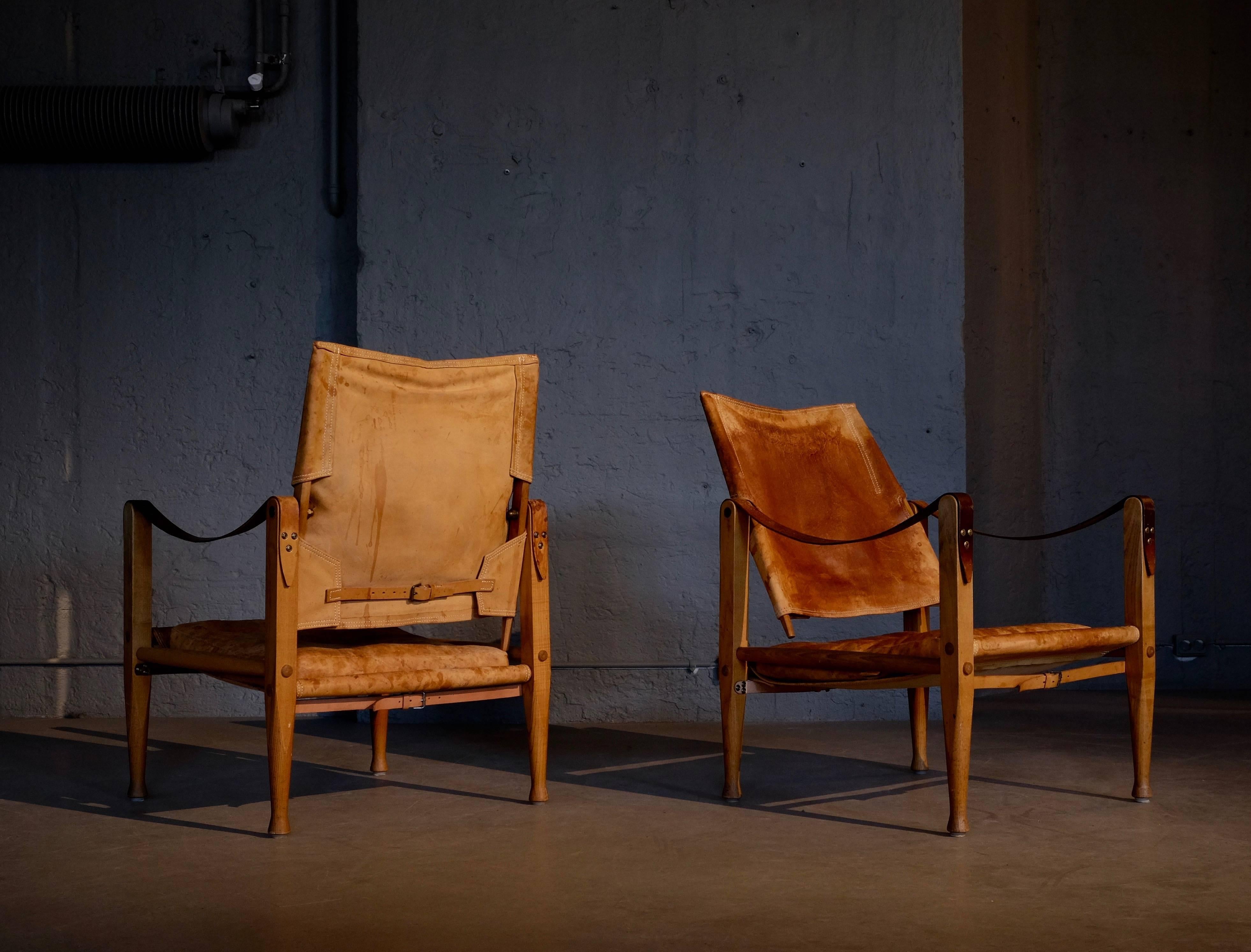 Pair of Safari chairs with patinated cognac brown leather. Designed by Kaare Klint in 1933, produced by Rud. Rasmussen, Denmark.
Please note: the condition of the cushions is not the best, some button missing and a few smaller holes on the sides,