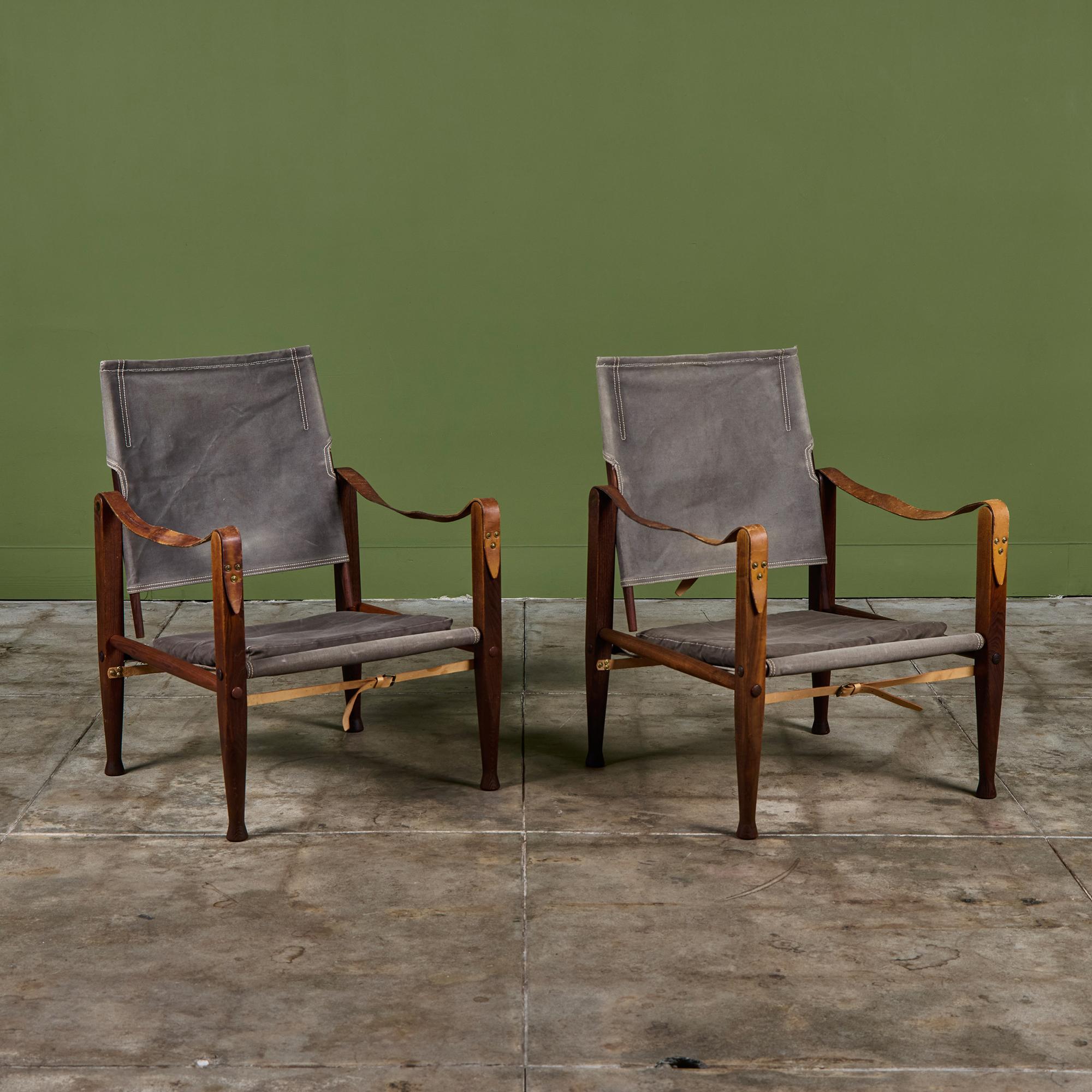 Dänische Sessel, 1933 von Kaare Klint entworfen und in den 1960er Jahren von Rud Rasmussen hergestellt. Dieses Paar besteht aus einem Eschenholzrahmen, der mit kamelfarbenen Lederriemen mit Messingbeschlägen zusammengehalten wird. Die Sitzfläche und