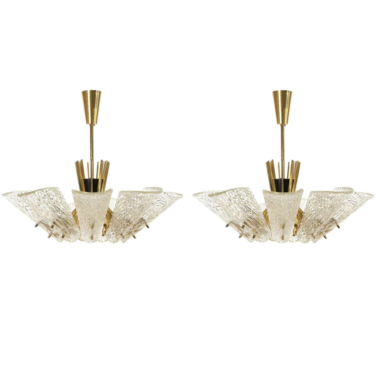 A set of two large glass and brass chandeliers by J.T. Kalmar, Austria, manufactured in Mid-Century, circa 1960 (late 1950s or early 1960s).
Each light has nine arms with sockets for small screw base E14 candelabra bulbs or LEDs (max. 40W per bulb)