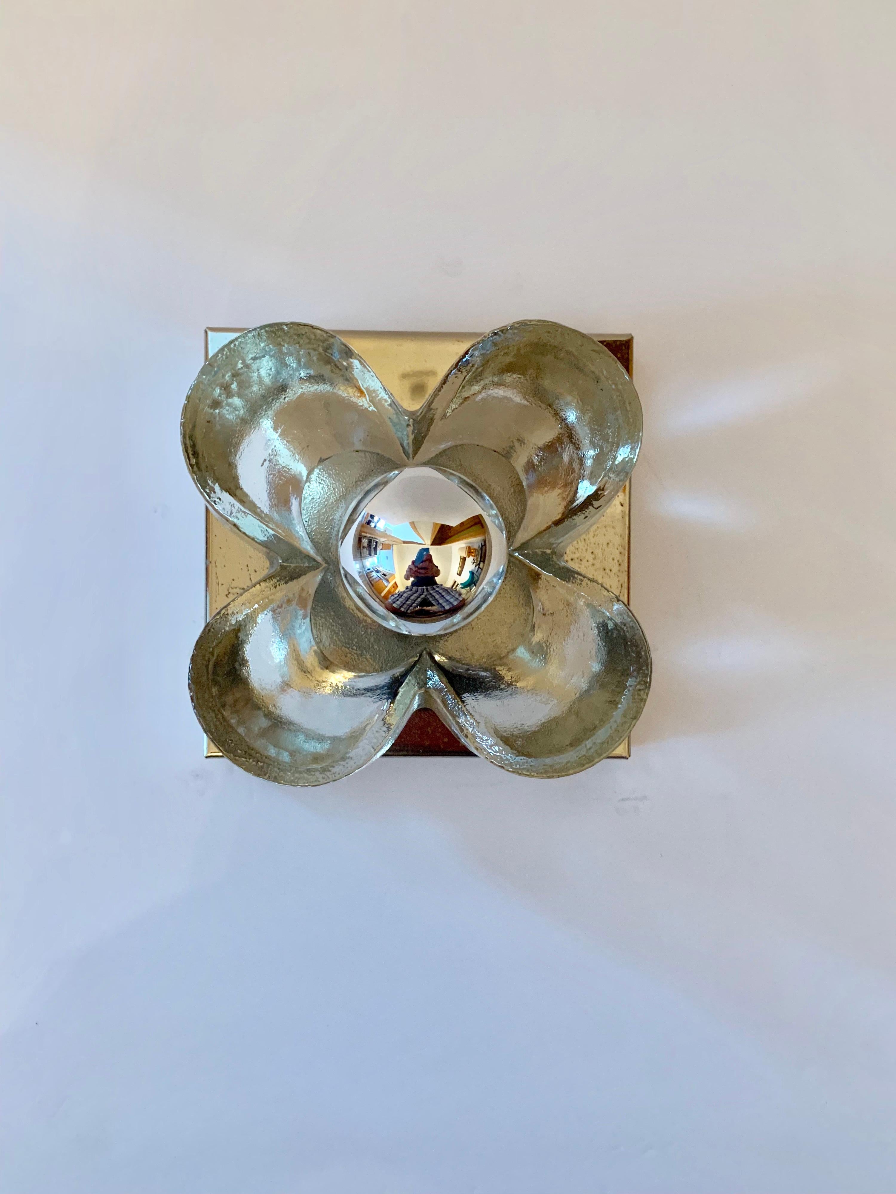 A pair of polished brass wall lights with thick glass floral shades. Newly rewired. Standard sockets.
