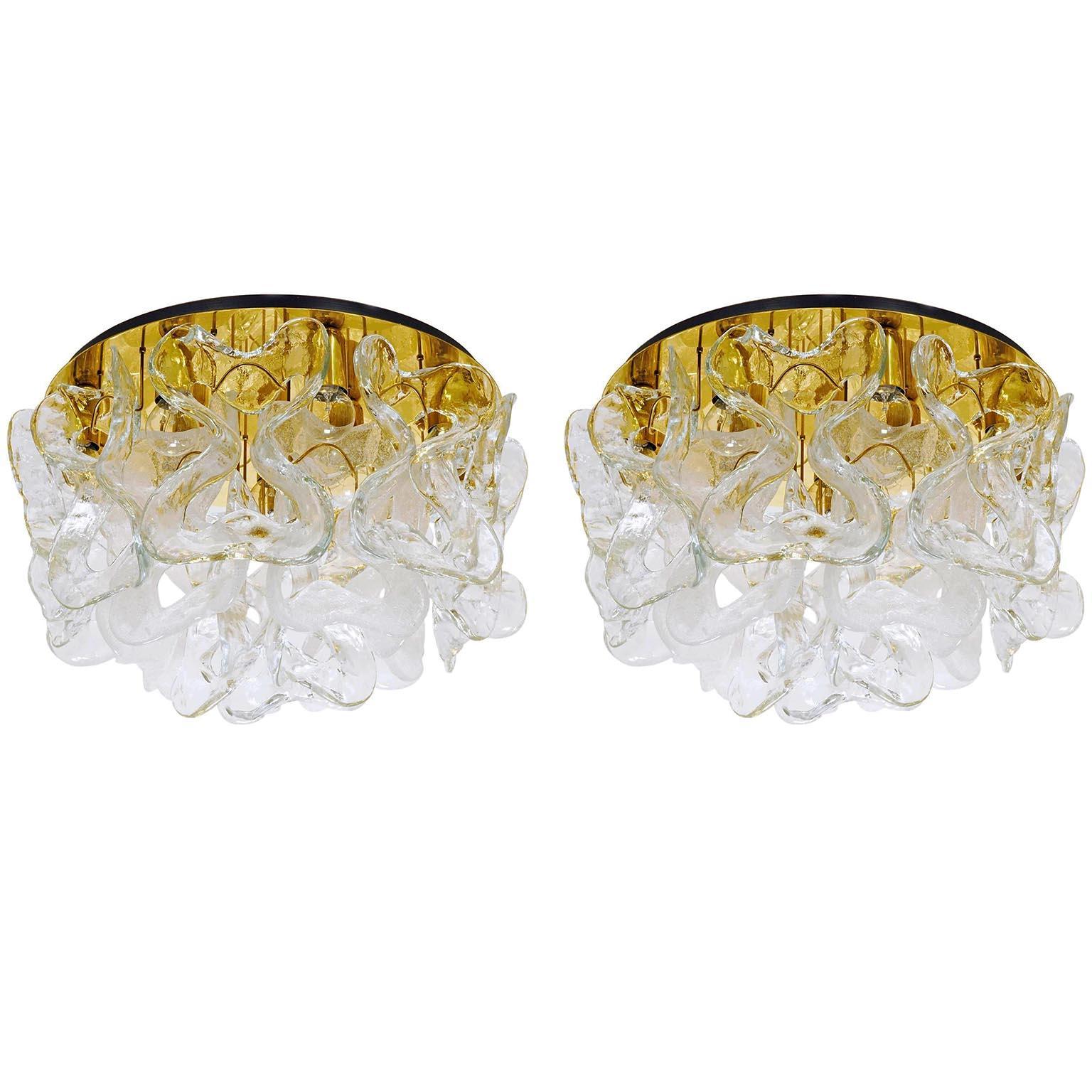 A pair of gorgeous flush mount lights model 'Catena' by Kalmar, Vienna, Austria, manufactured in midcentury, circa 1970 (late 1960s or 1970s).
18 large 'ribbons' in clear (12 pieces) and white bubble Murano glass (6 pieces) hang on a polished brass