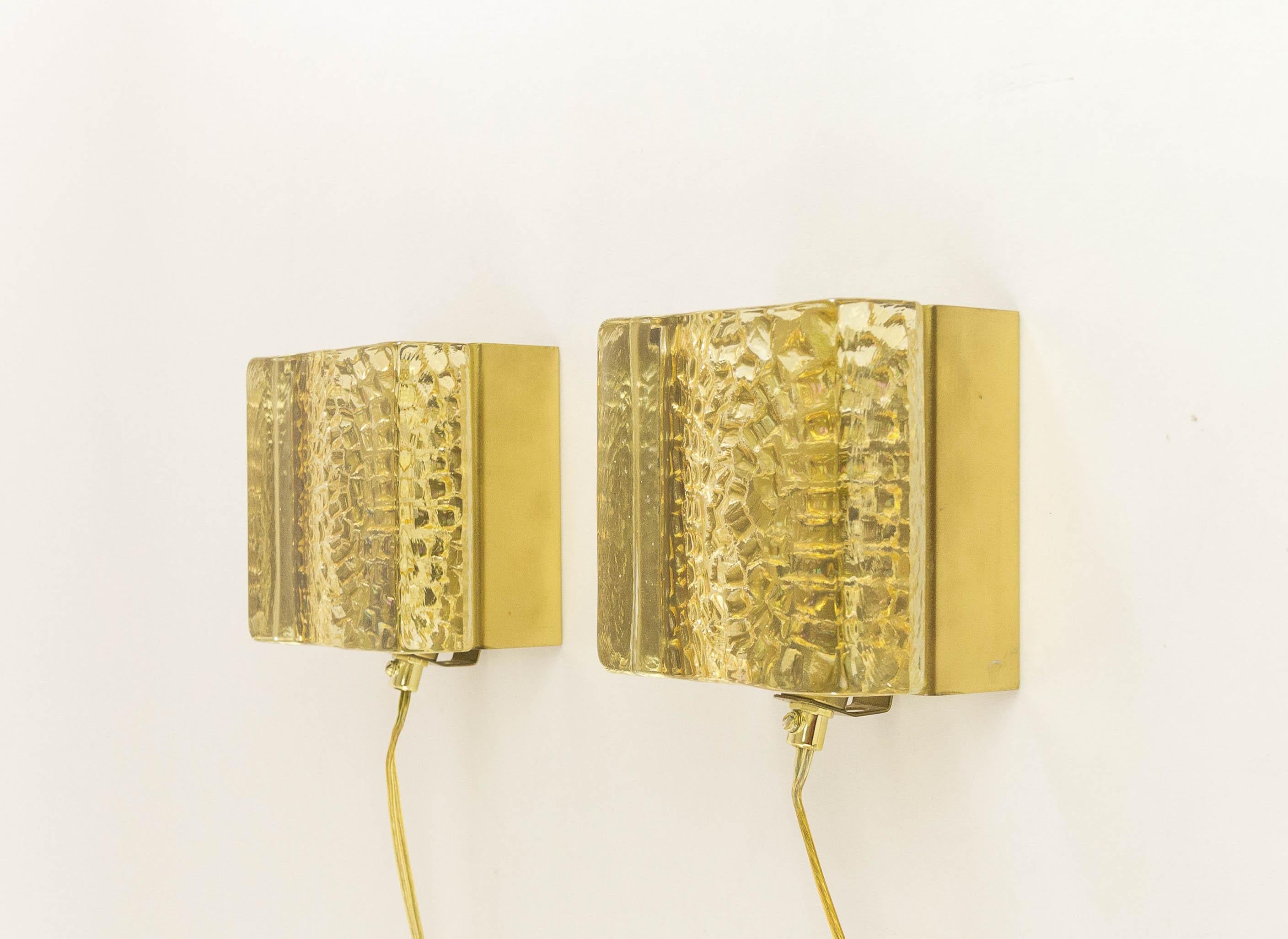 A set of two Kalmar Lampet wall lamps, produced by Danish lighting manufacturer Vitrika in the 1970s.

Both lamps consists of two parts: a solid and rather heavy (1.5 kg / 4 lb) handmade glass body in gold, and the brass holder.

Price is for the