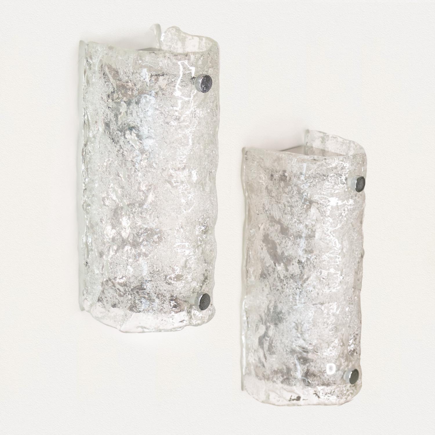 Beautiful pair of Kalmar glass sconces. Thick clear textured glass in rectangular tube form with chrome backplate. Newly re-wired with single socket in each sconce. Great for powder room. Each takes one E12 base bulb, up to 25 W or higher with
