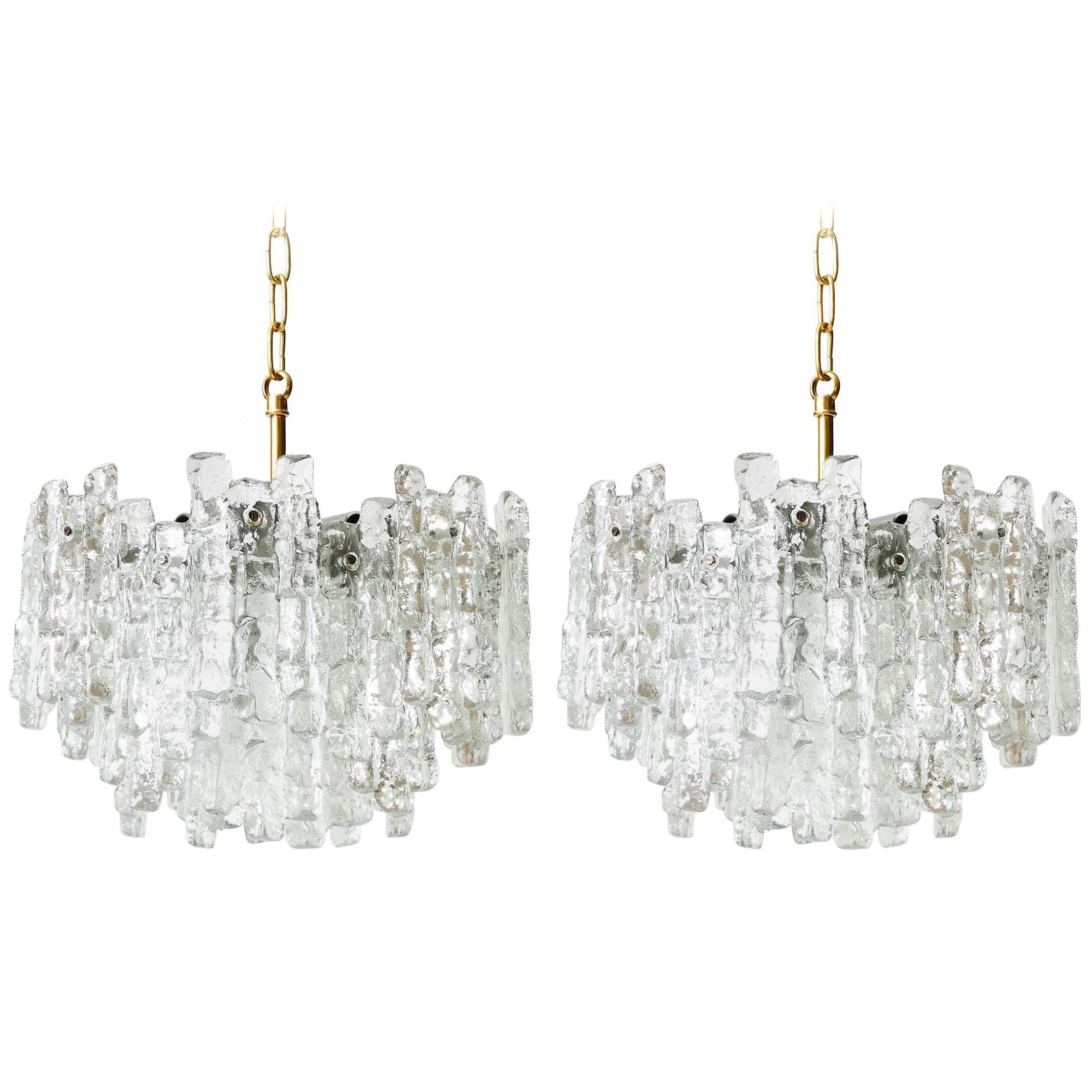 A pair of beautiful ice glass light fixtures by Kalmar, Austria, manufactured in midcentury, circa 1970 (late 1960s or early 1970s). Each chandelier is made of 28 massive ice blocks which are mounted on a silver painted metal frame.
Each fixture