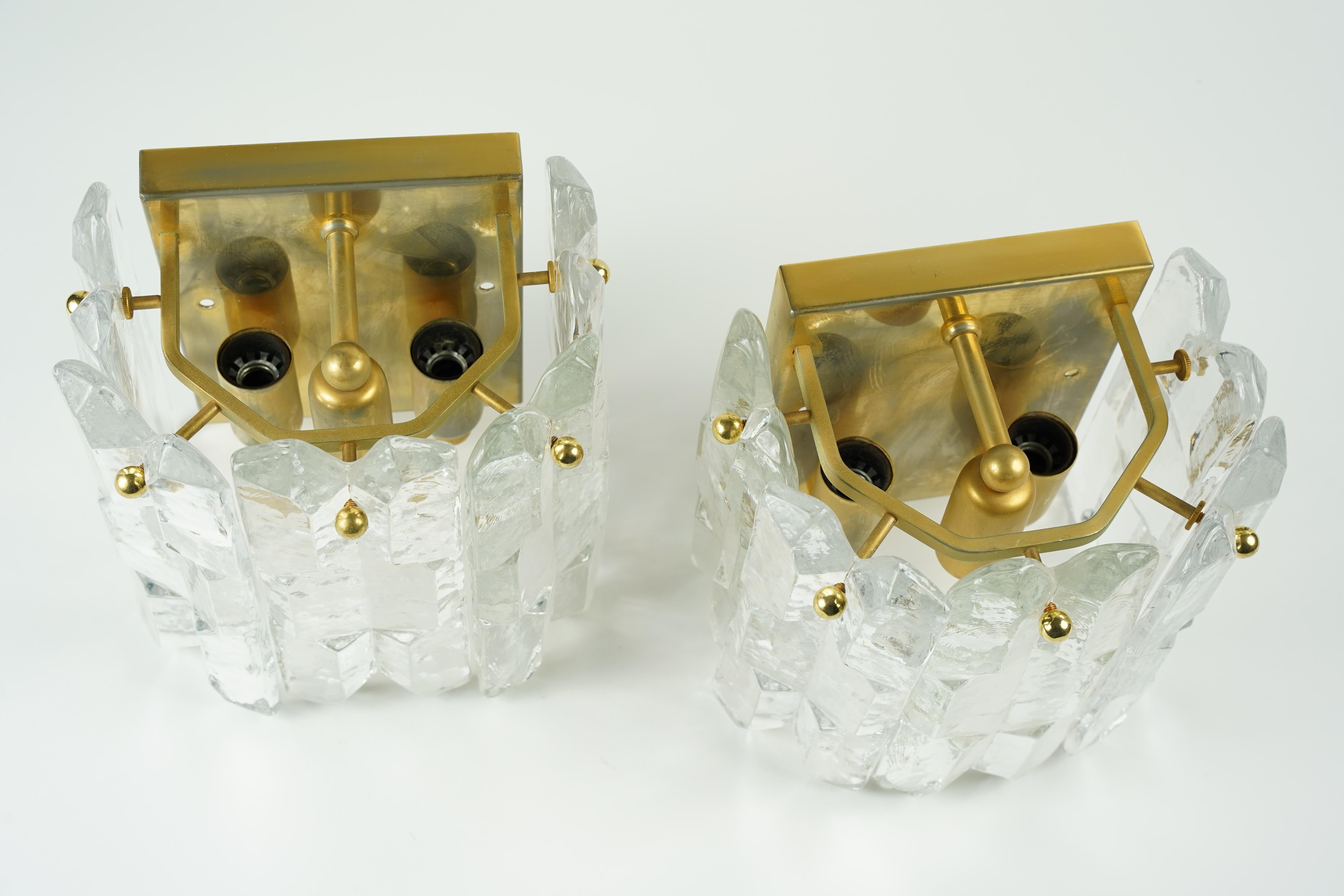 Pair of Kalmar palazzo crystal sconces 1970s Vienna Austria, five thick clear heavy pieces of highest quality press crystal mounted on a gilt gold frame. 
Three candelabra light sockets.