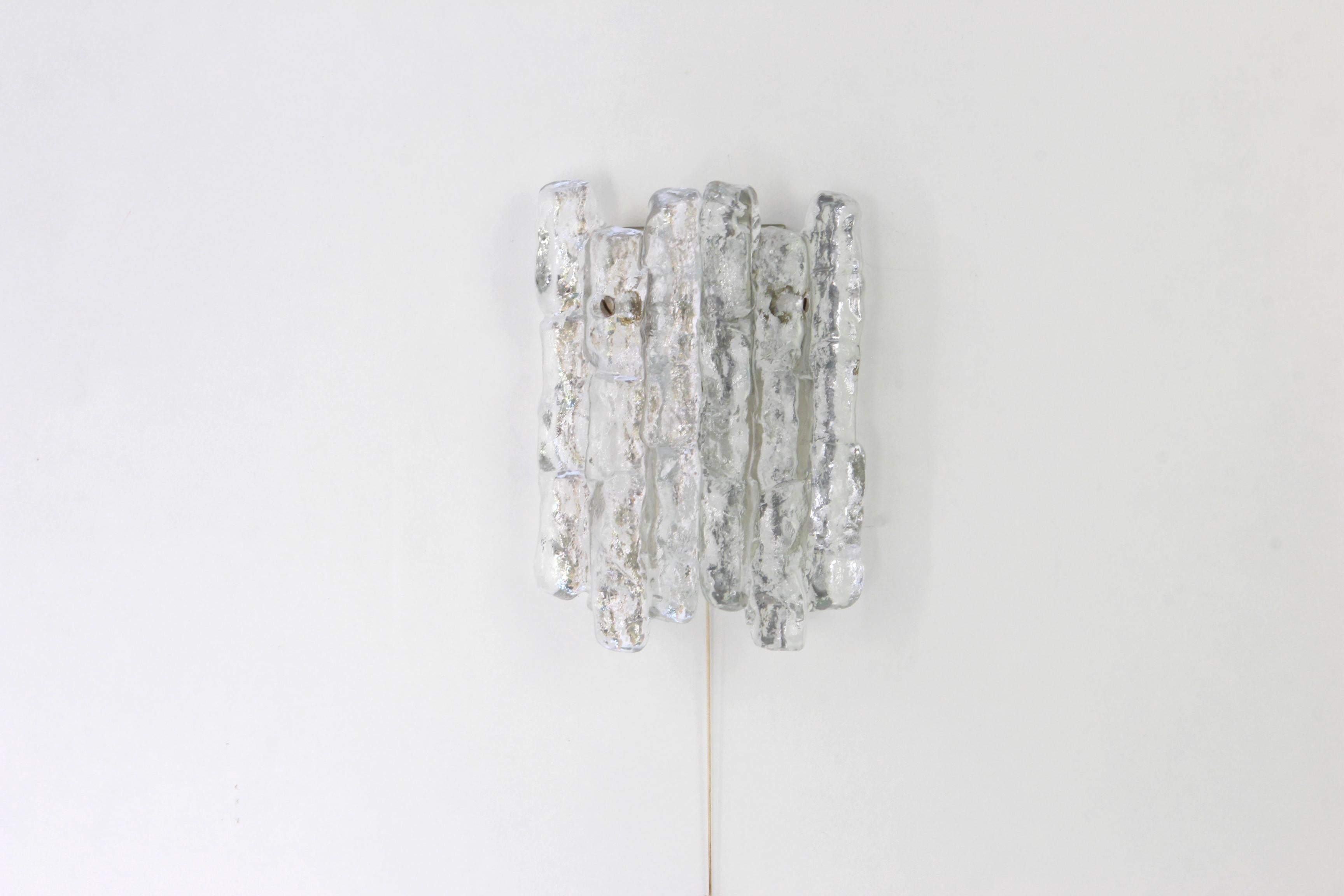 Wonderful pair of midcentury wall sconces with ice glass, made by Kalmar, Austria, manufactured, circa 1960-1969.
High quality and in very good condition. Cleaned, well-wired and ready to use.  

Each sconce requires 1 x E14 standard bulbs with