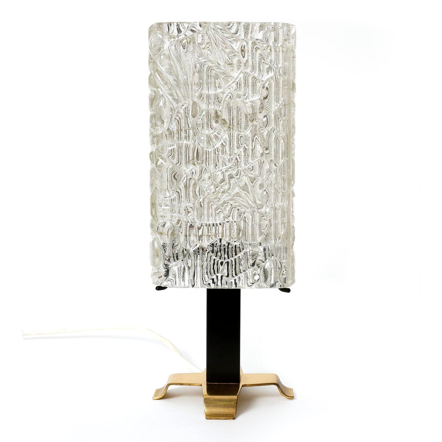 A lovely pair of table lamps by J. T. Kalmar, Austria, manufactured in midcentury, circa 1960 (late 1950s or early 1960s).
They are made of a polished brass base and a blackened metal stand which holds a square textured glass. A switch is on the