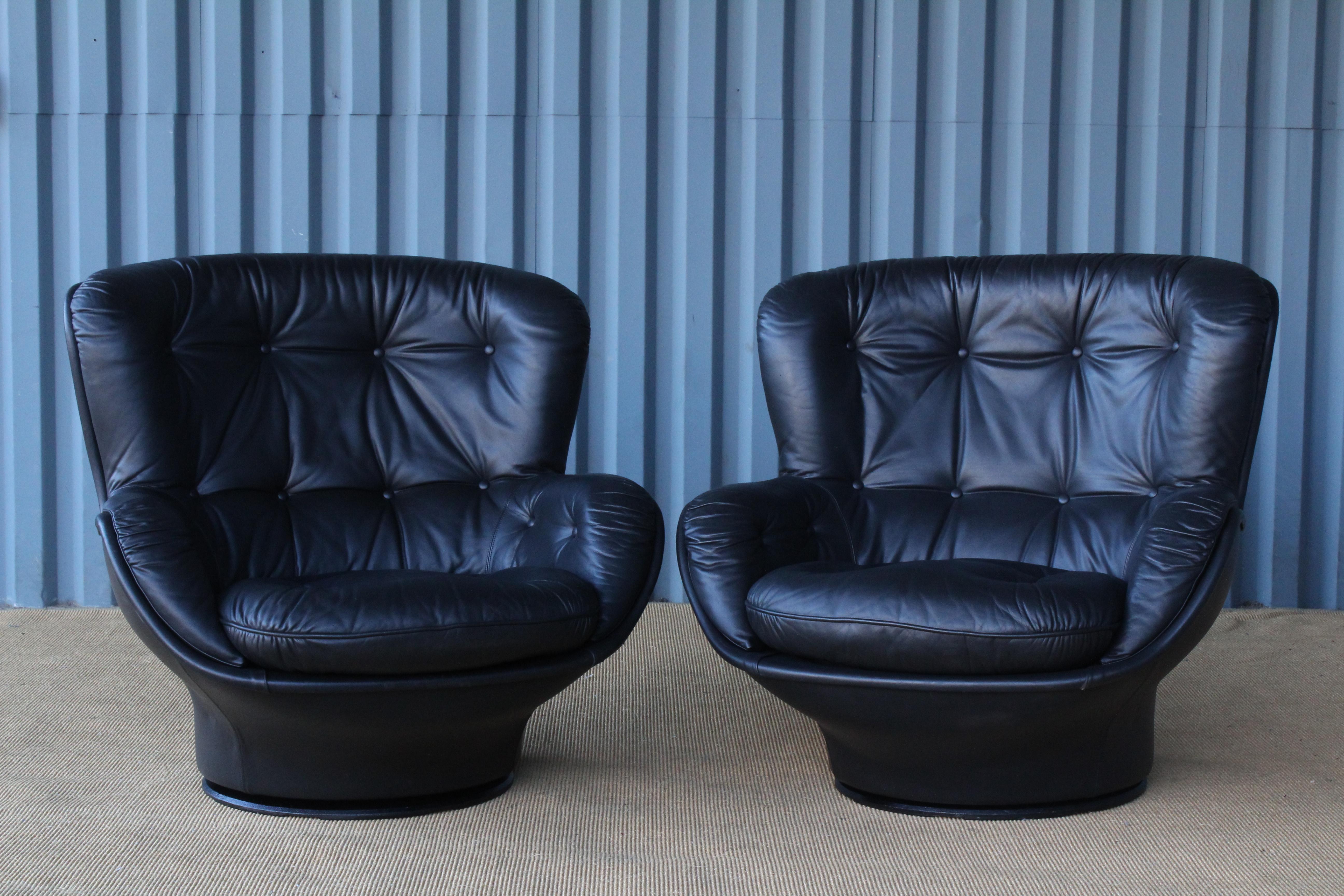 Pair of leather swivel lounge chairs designed by Michel Cadestin for Airborne. Leather over a fiberglass shell, loose seat cushions and sit upon an iron base. Sold and priced as a pair.