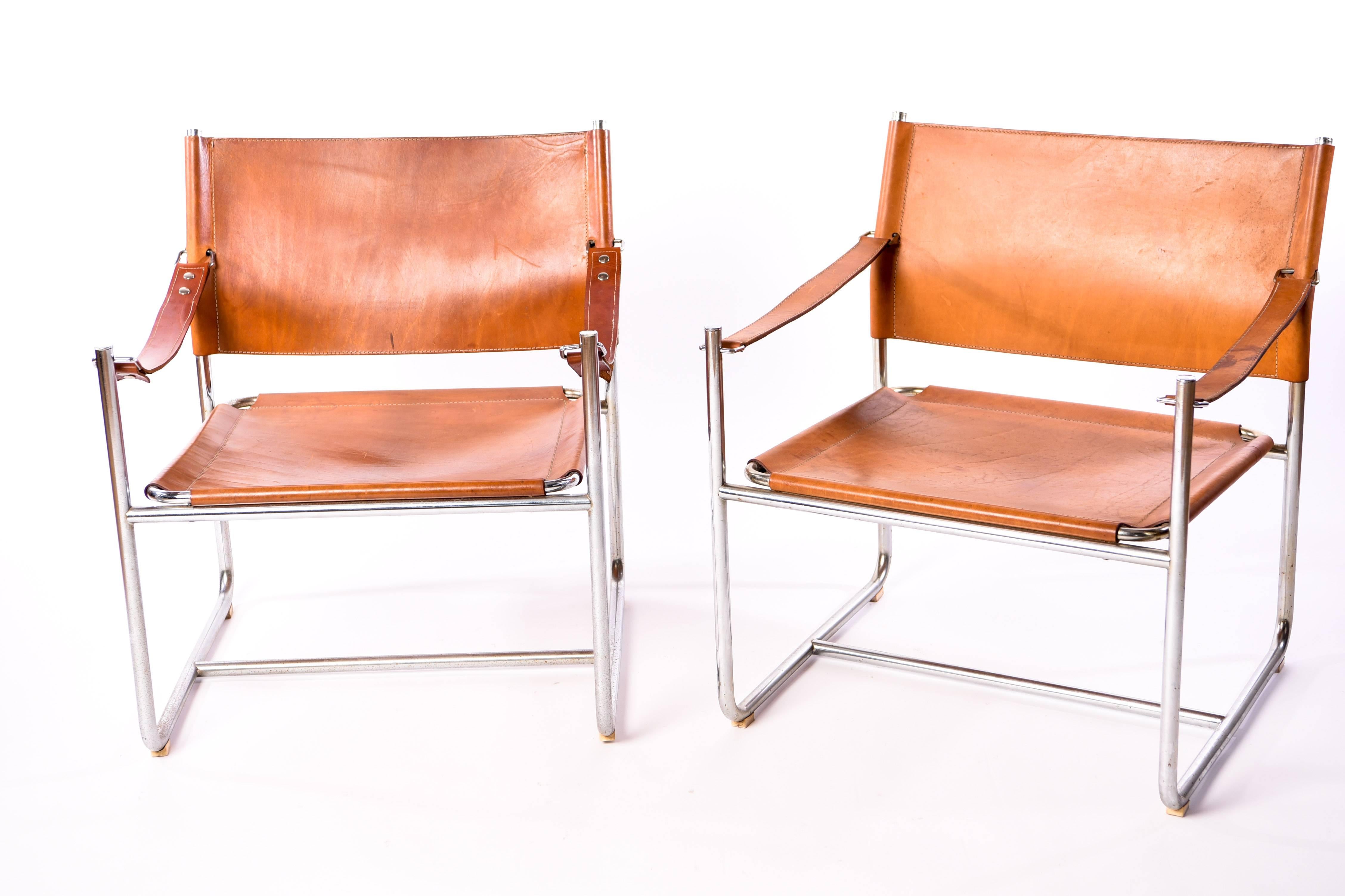 The 'Admiral' leather safari chair was designed by Karin Mobring for Ikea in the early 1970s. It is made from a chrome frame and patinated leather. This beautiful pair has a Classic midcentury appeal.