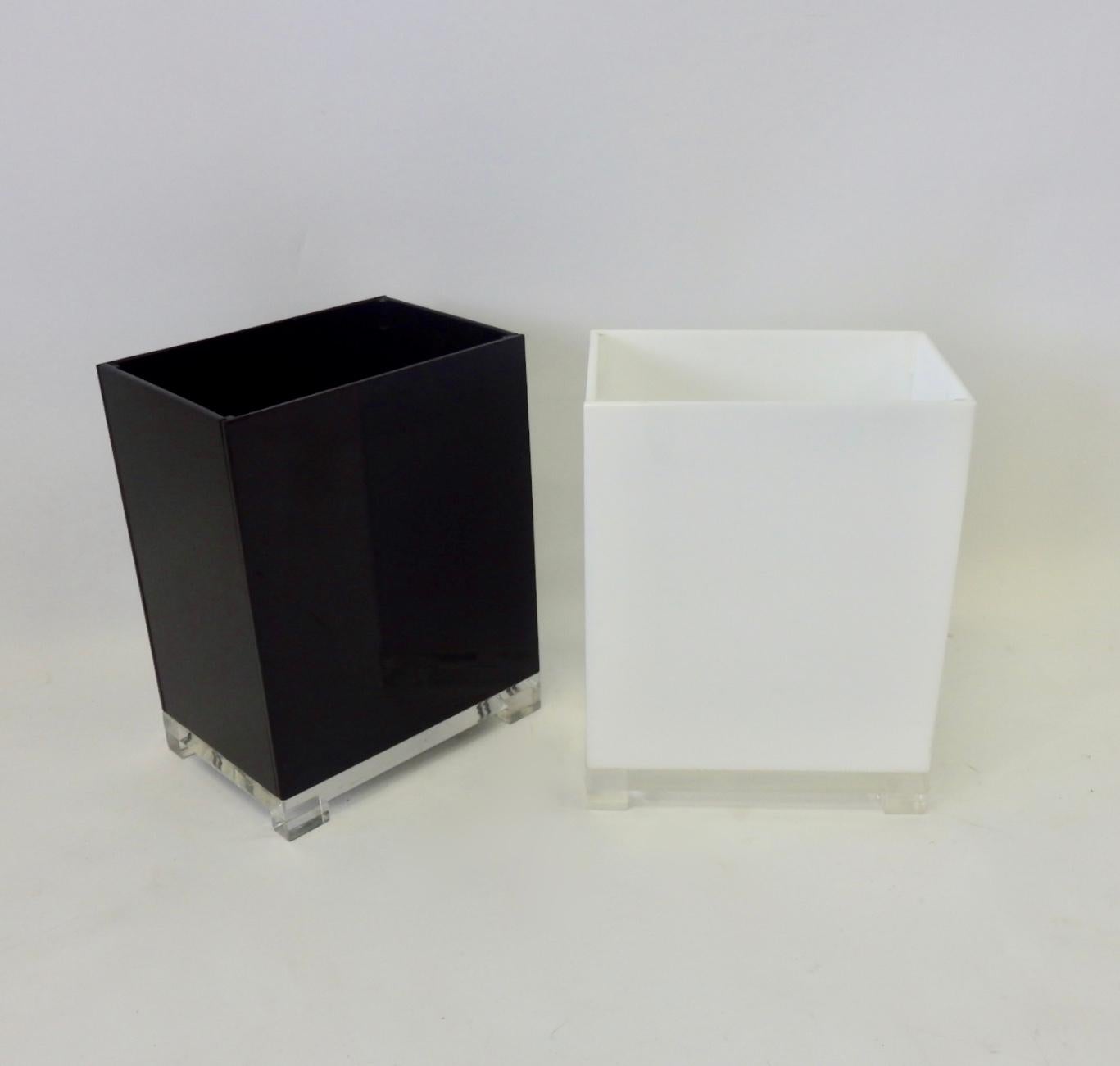 Pair of Lucite trash cans one black one white. Excellent condition.
