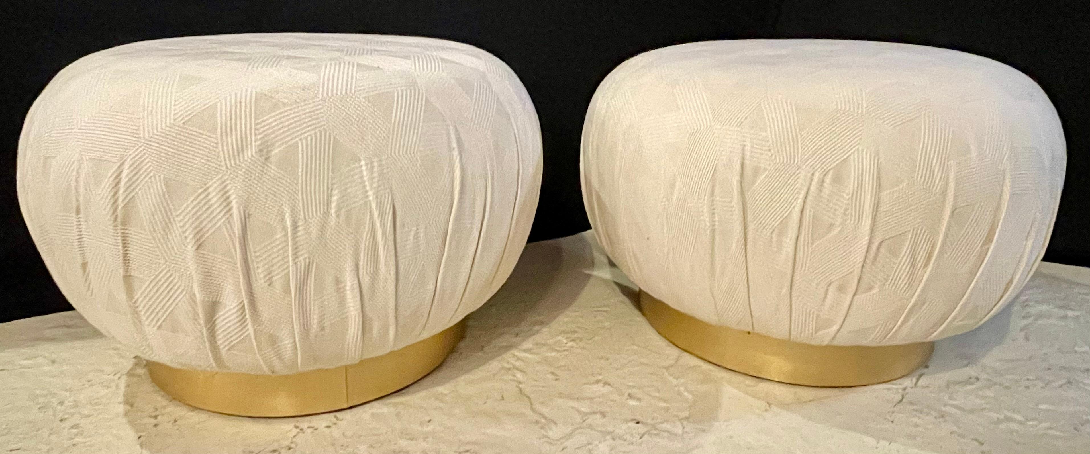 Pair of Karl Springer style oversized ottoman or Poufs, Soufflé. A large and impressive pair of ottomans that can easily be used as seats. Done in a nice raised fabric sitting on gilt metal bases. 


LXX.