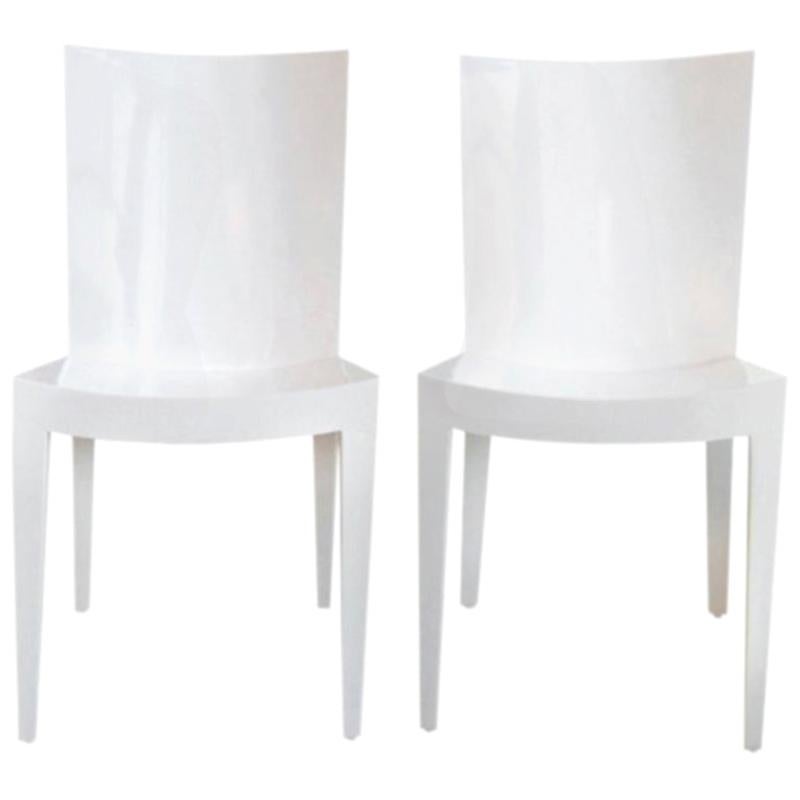These pair of high gloss white lacquered wood KMF chairs by Karl Springer are simultaneously sculptural and linear with concave seats and backs. Surprisingly comfortable and very chic. Great for many placements in your home. These would make great