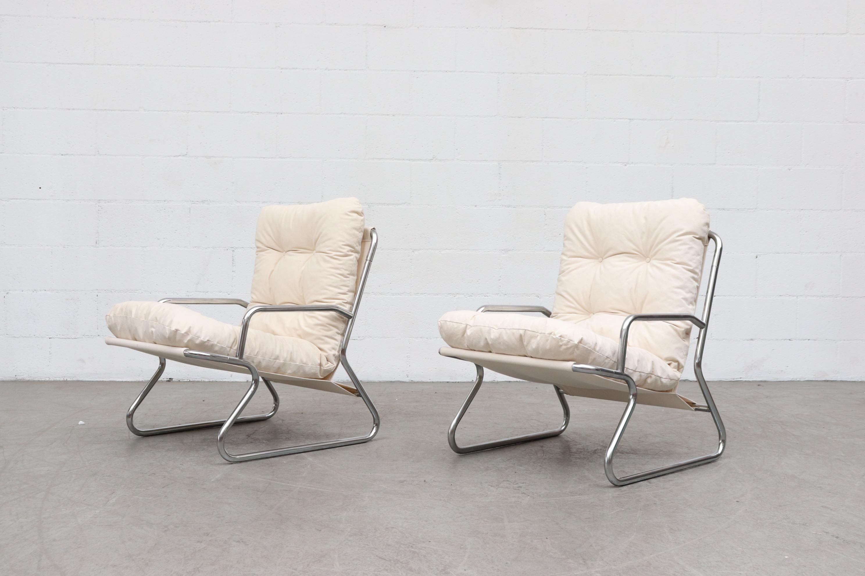 Pair of tubular chrome and natural canvas upholstered lounge chairs newly upholstered sling support and cushions, chrome frames in original condition with wear consistent with their age and usage. Set price. Another similar set is available and